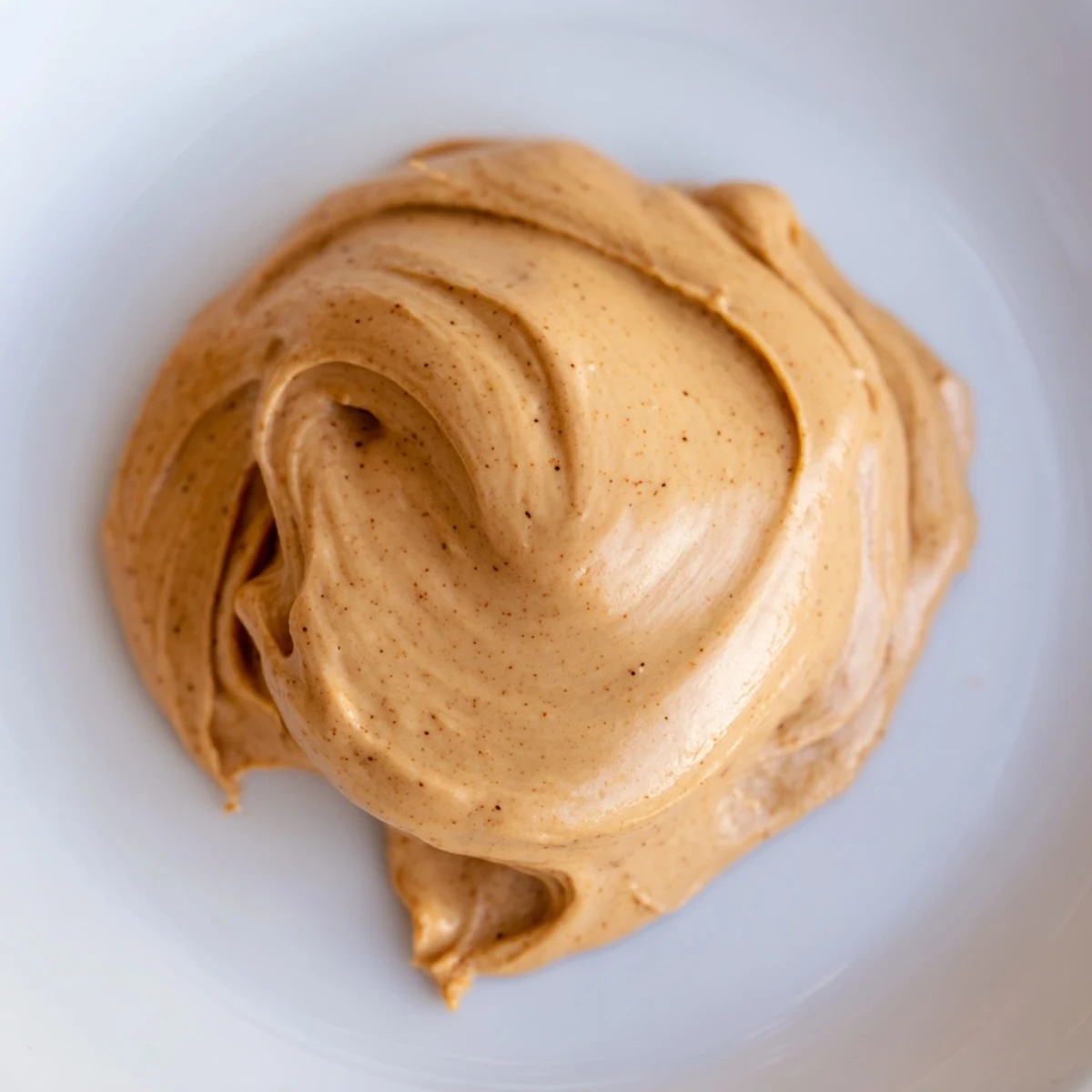 Freshly whipped gingerbread frosting with sugar, ready to spread on warm gingerbread cookies.