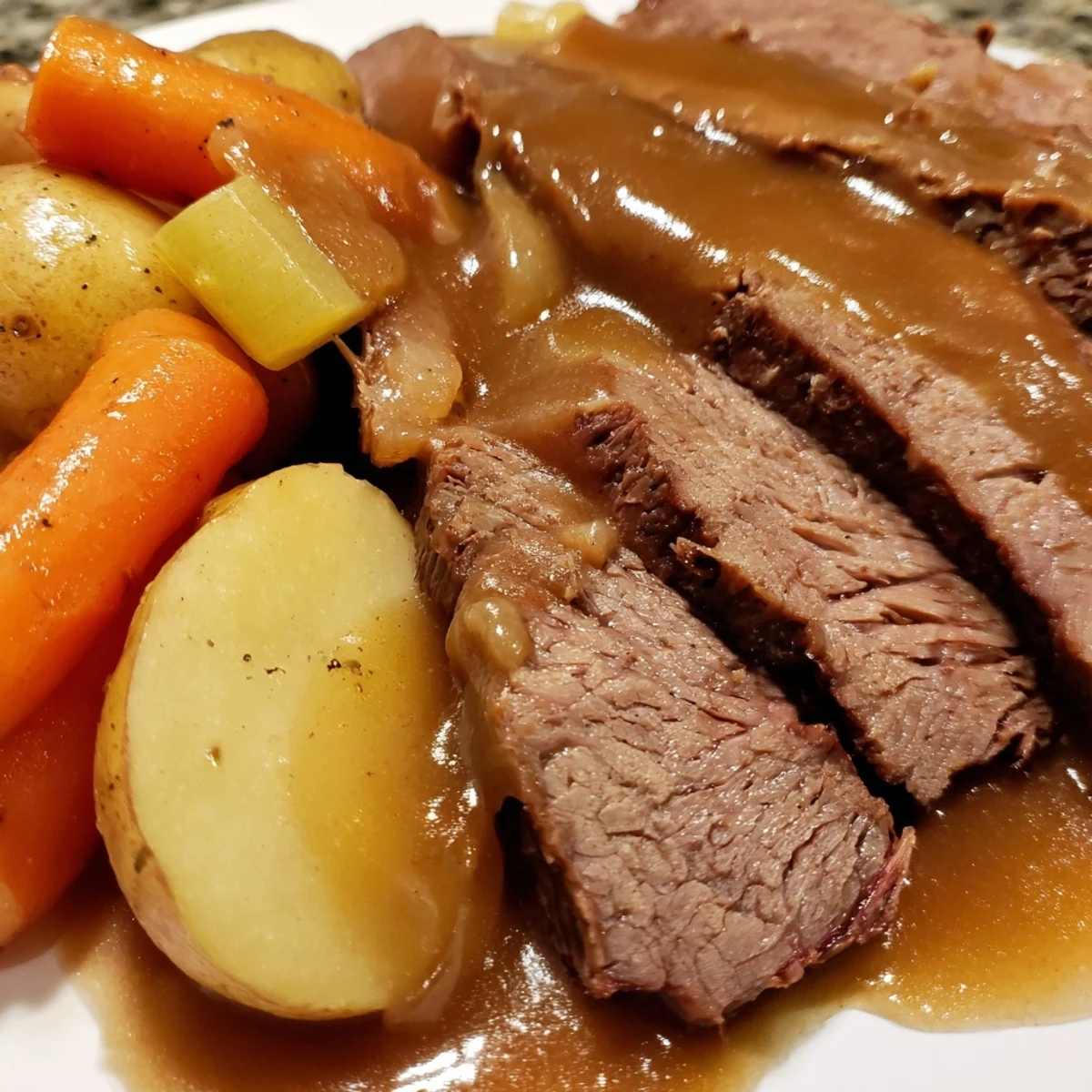 Tender Slow Cooker Pot Roast with Carrots on a platter with savory juices and herbs.
