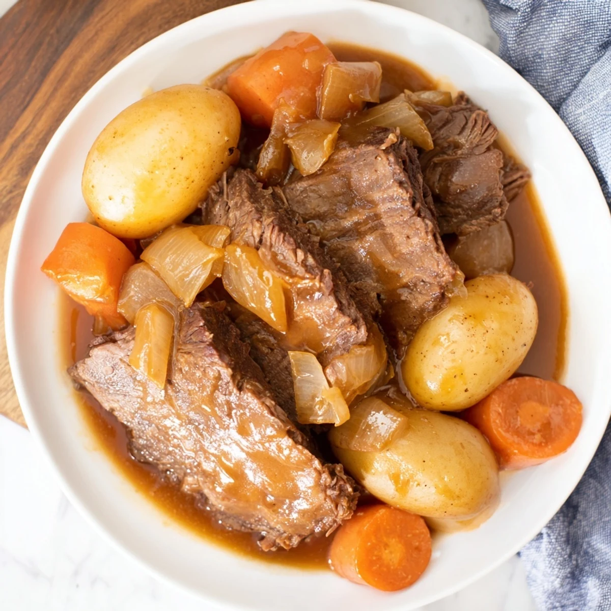 Irish Beef Pot Roast plated with carrots and potatoes, generously drizzled with savory gravy.