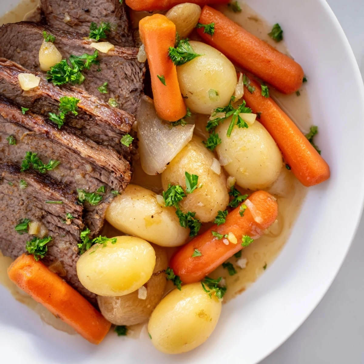 Golden-brown Irish Beef Pot Roast with Carrots and Potatoes, simmering in a rich, savory broth in a Dutch oven.