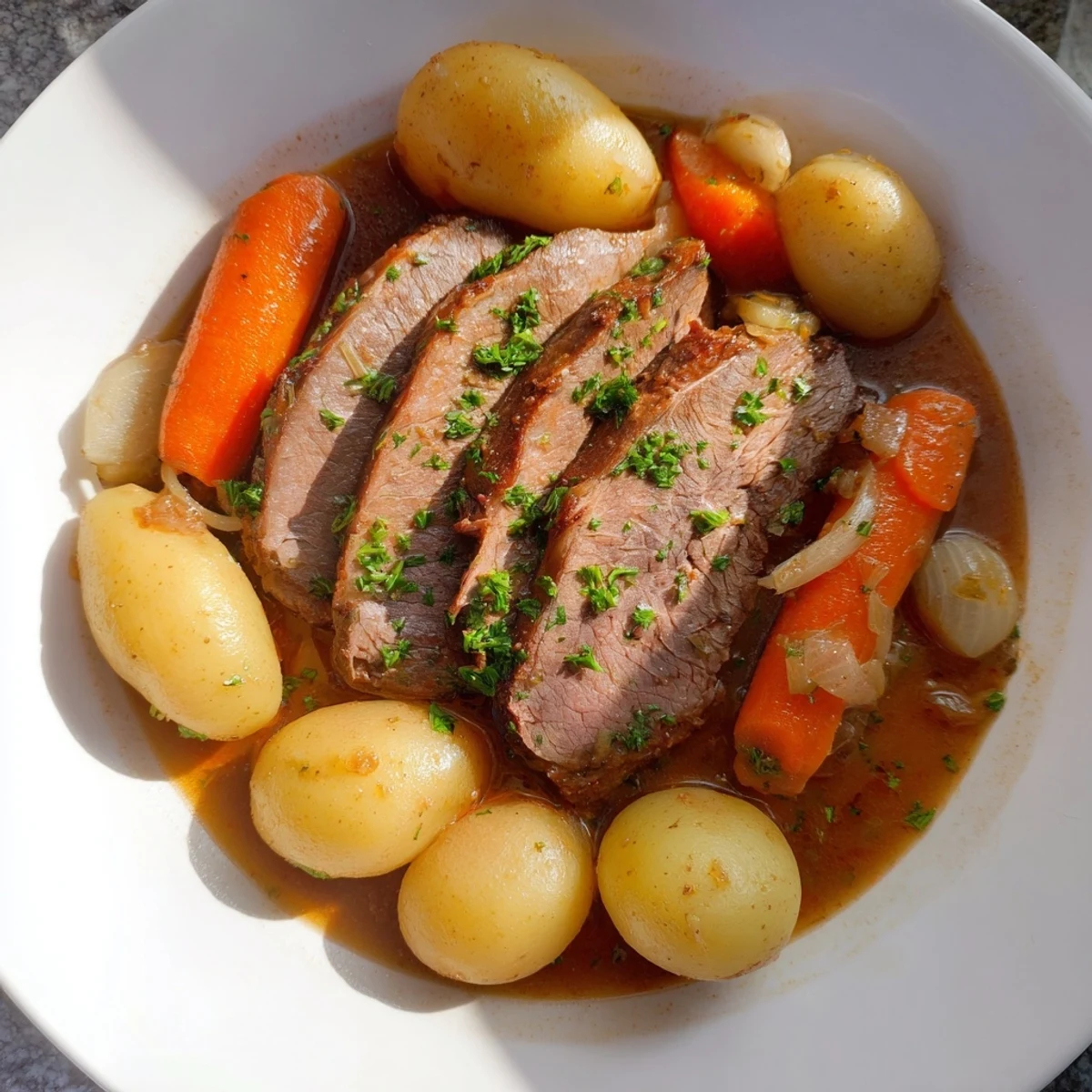 Hearty Irish Beef Pot Roast with carrots and potatoes, garnished with fresh parsley for a comforting family dinner.