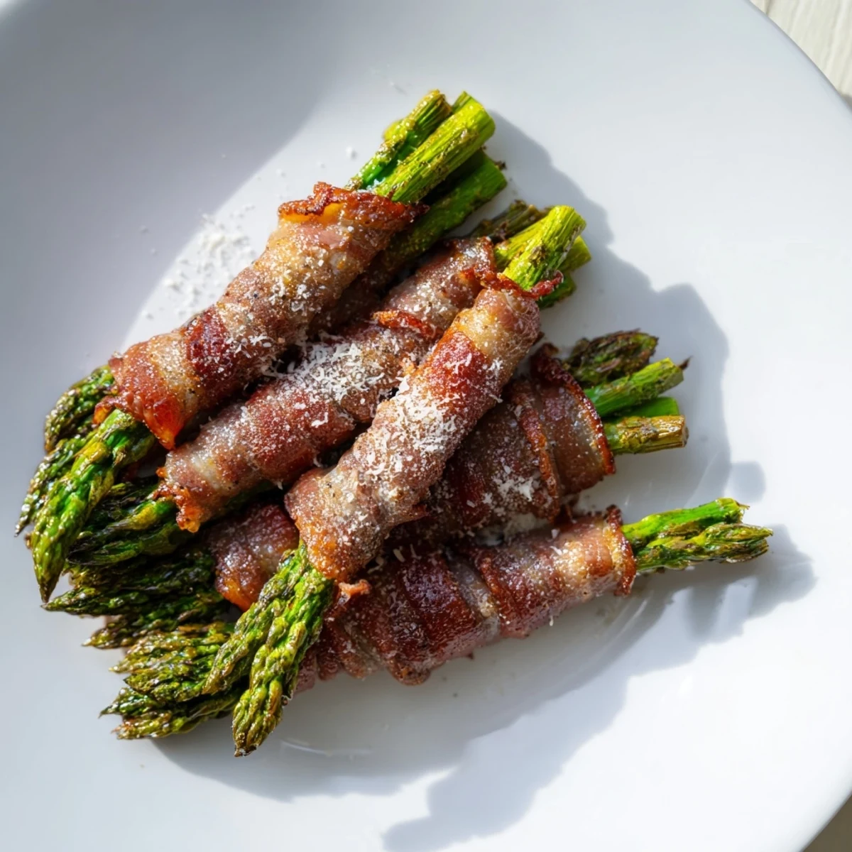 Golden roasted asparagus spears wrapped in smoky beef bacon, arranged neatly on a baking sheet for a gluten-free appetizer.