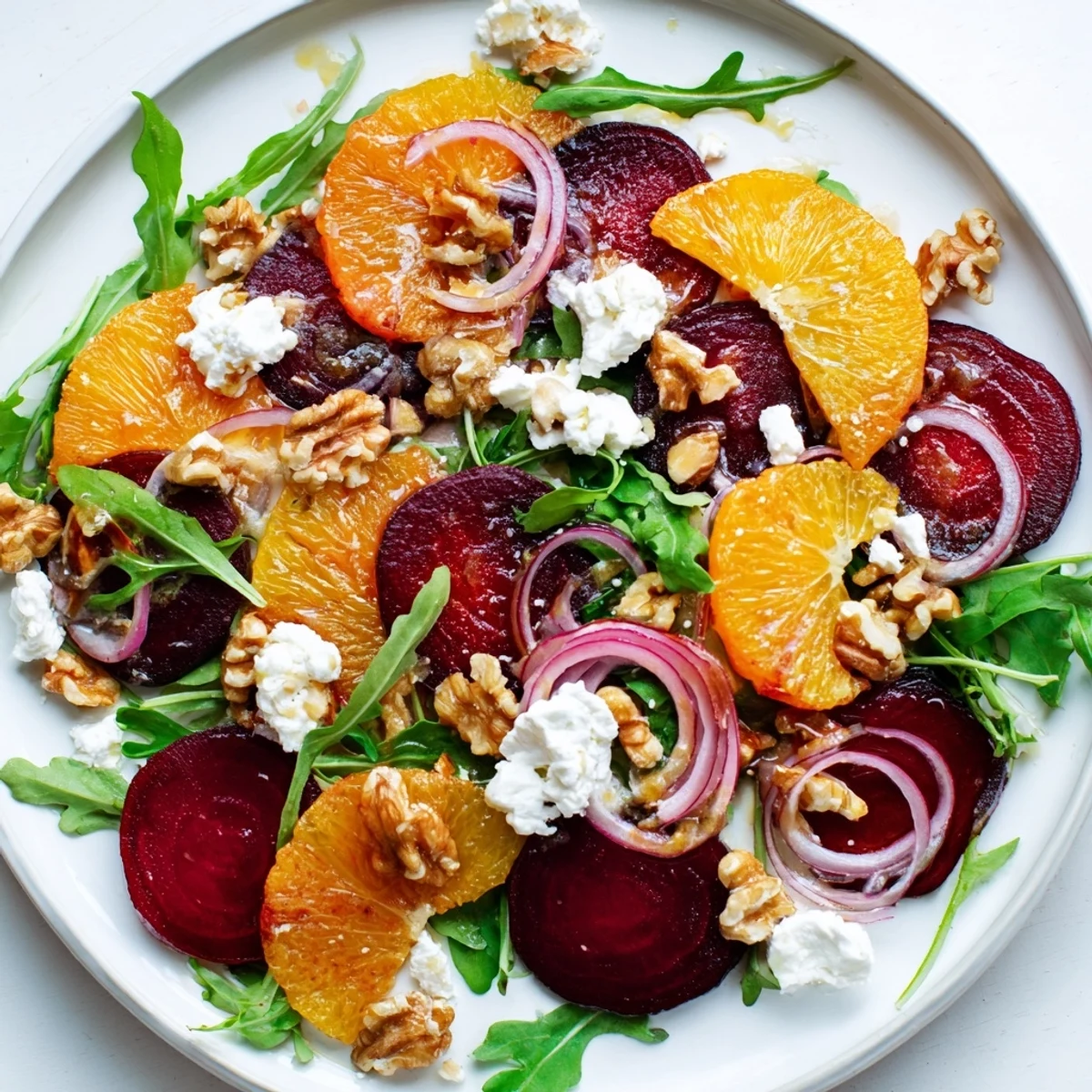Vibrant roasted beet and citrus salad with crunchy toasted walnuts and creamy crumbled goat cheese on arugula. 