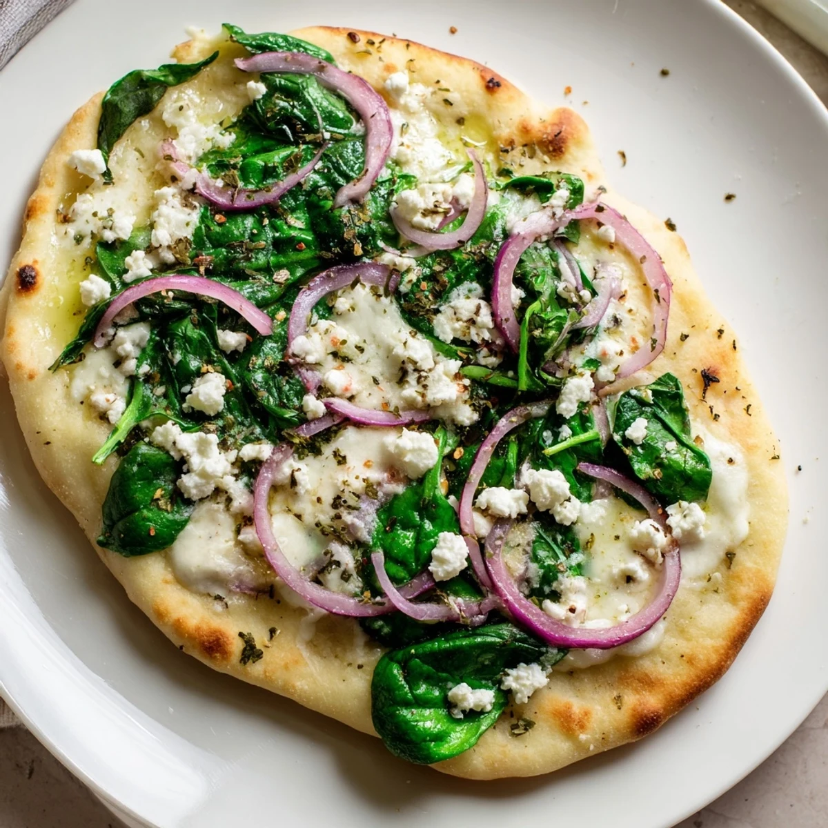 A Mediterranean-inspired Spinach and Feta Flatbread Pizza cut into wedges, ready to serve for dinner.