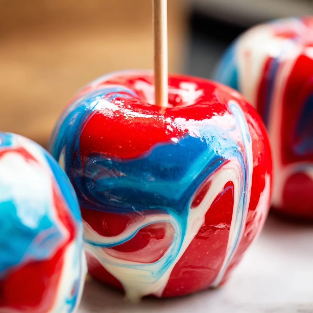 Freshly dipped marbled effect candy apples display vivid swirls and a crunchy candy shell on a clean serving platter.