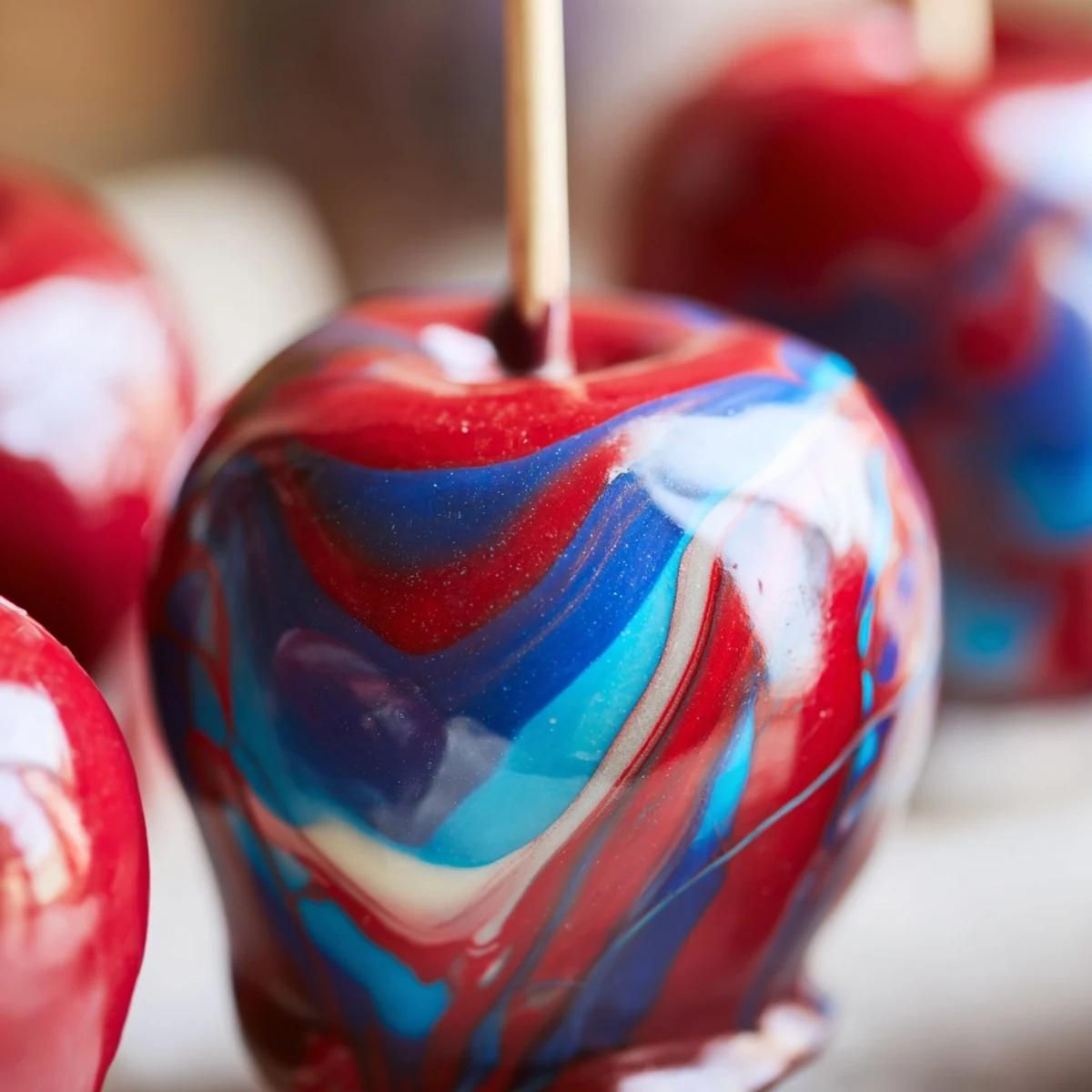 A close-up of marbled effect candy apples reveals crackling glossy coating and crisp apple beneath, ready for autumn parties.