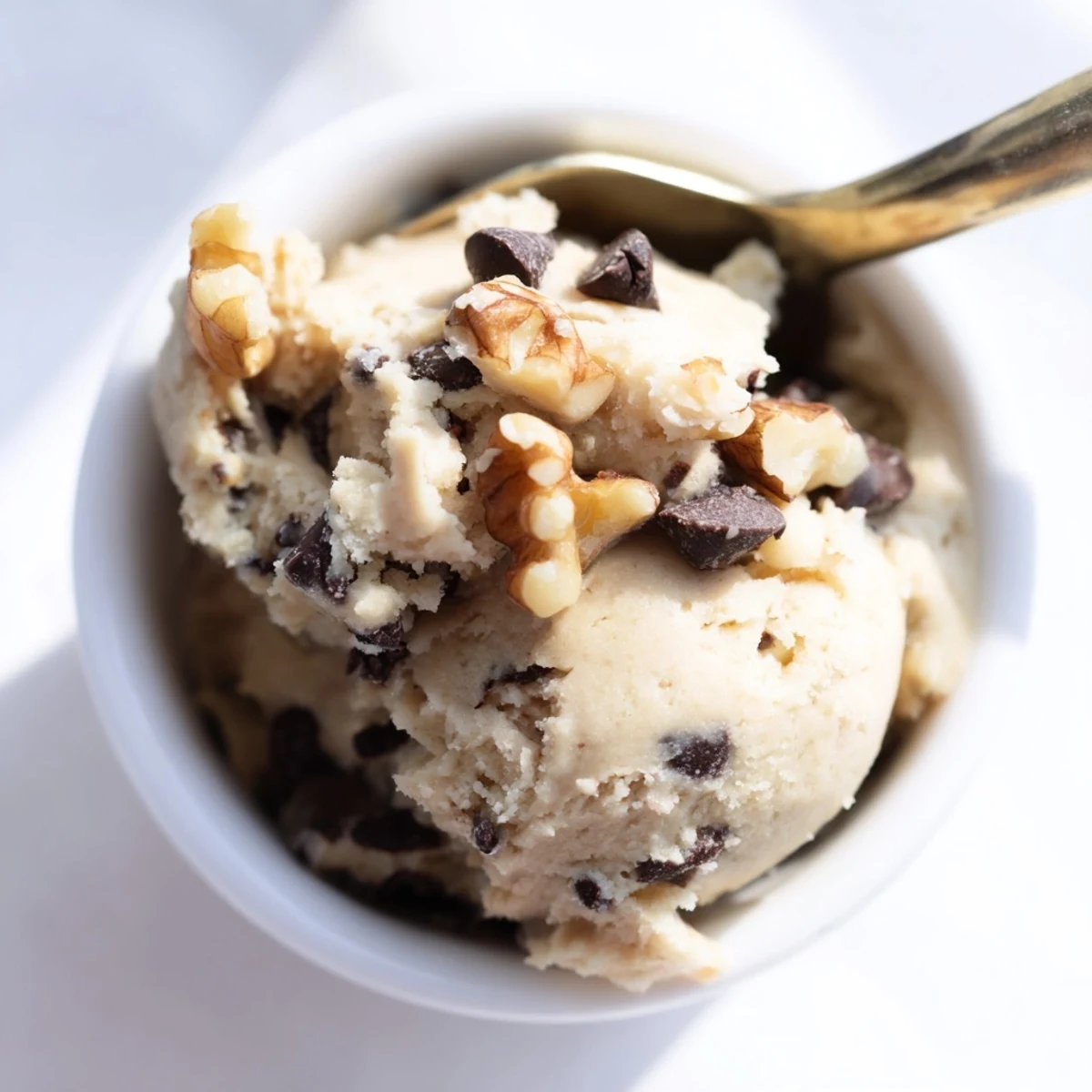 This healthy no-bake Guilt Free Greek Yogurt Cookie Dough dip sits in a bowl, ready to serve with apple slices.