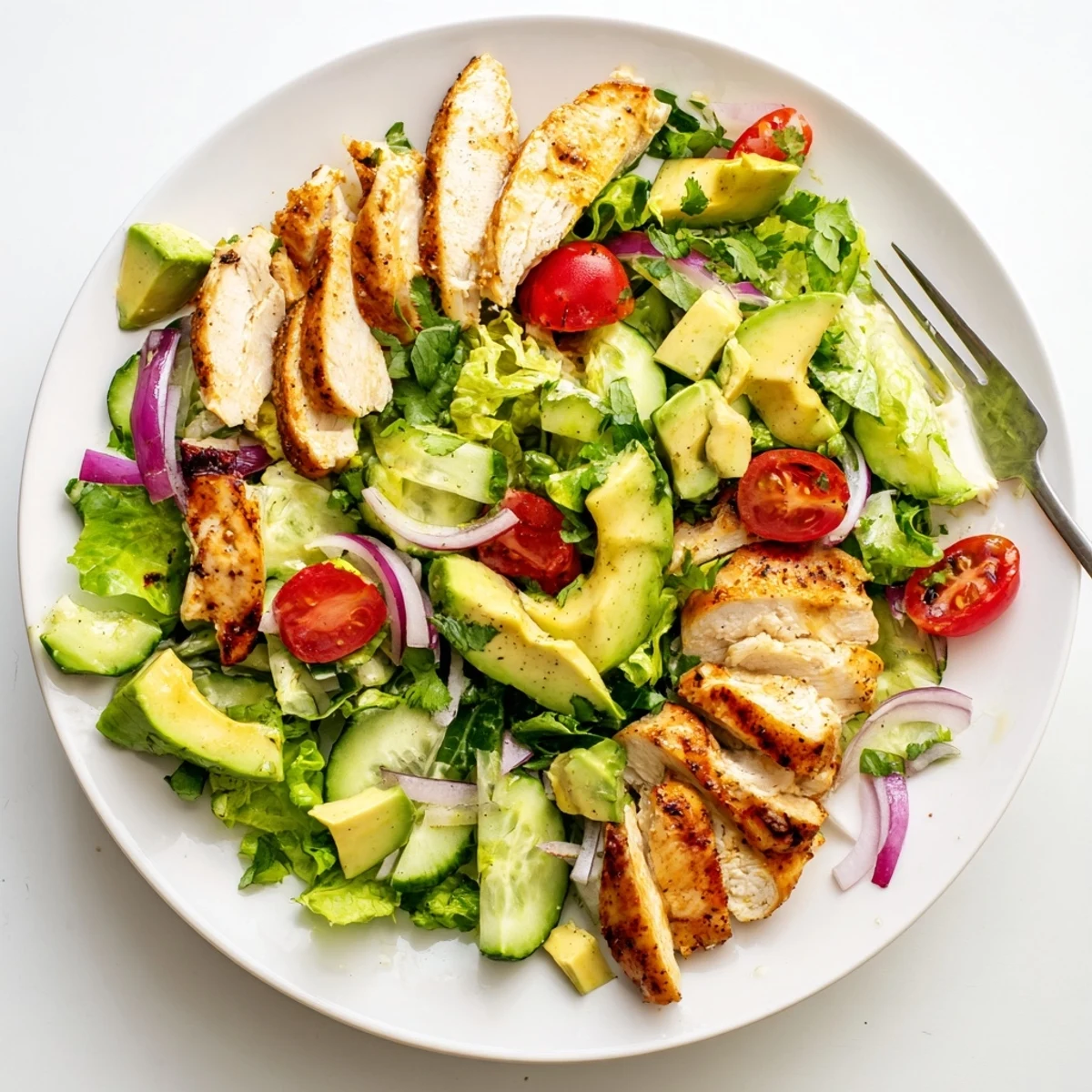 A vibrant Avocado Chicken Salad bowl features juicy diced chicken, ripe avocado chunks, and a light lime dressing, perfect for a healthy lunch.
