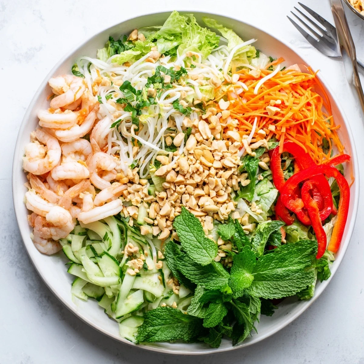 Colorful Spring Roll Salad with spicy ginger dressing featuring crisp vegetables, fresh herbs, and succulent shrimp