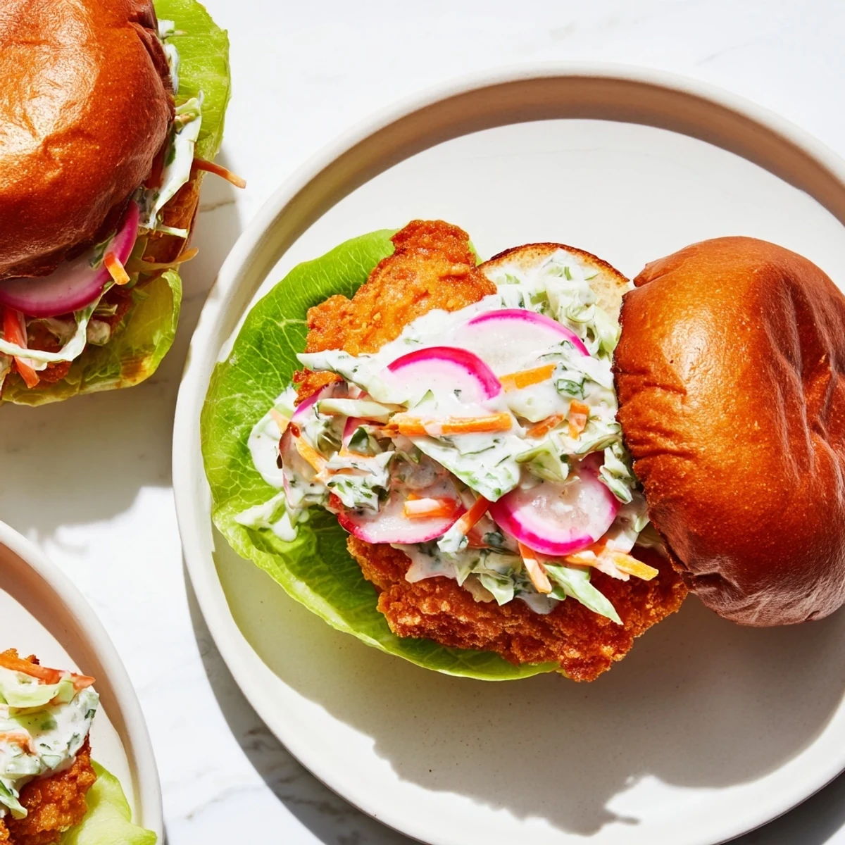 Juicy fried buffalo chicken breast sandwich with crunchy cabbage slaw and lettuce on soft bun
