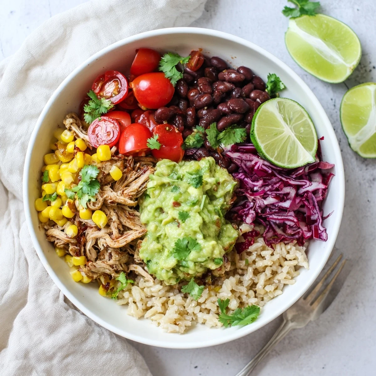 Nutritious gluten-free pulled chicken guacamole bowl served with brown rice, black beans, and crisp red cabbage