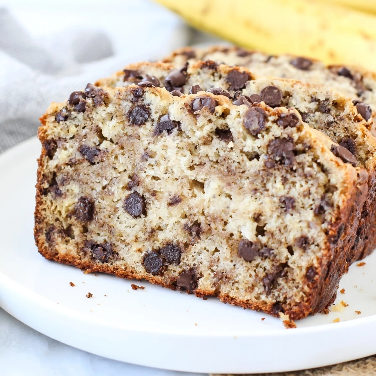 Golden chocolate chip banana bread loaf with melted chocolate chunks on top