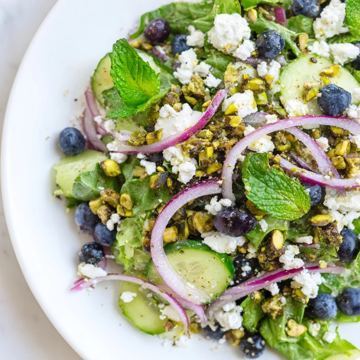 Crispy cucumbers and sweet blueberries crown this colorful Blueberry Pistachio Spring Salad beautifully