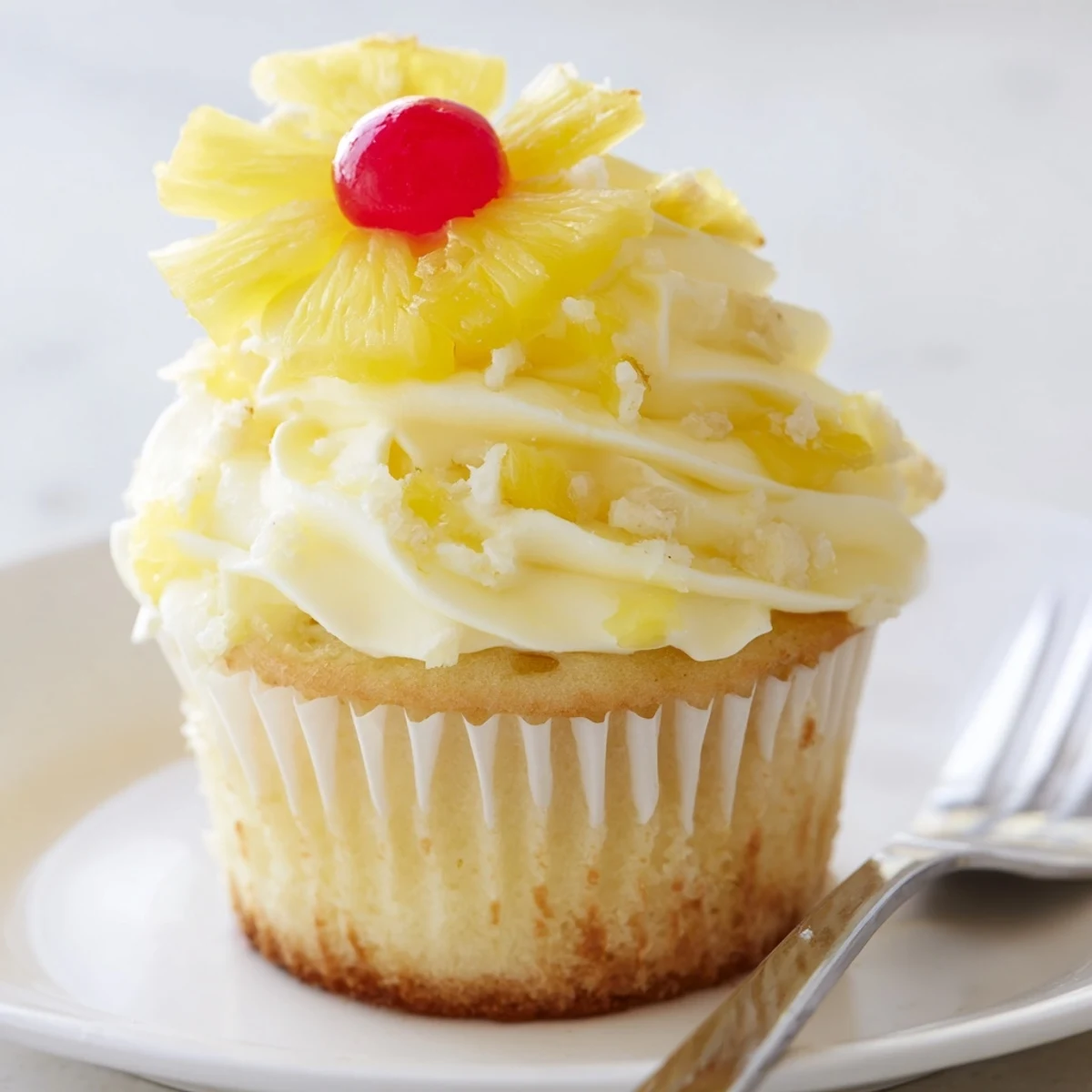 Dole Whip Cupcakes Recipe shown with fluffy pineapple frosting and tropical garnish