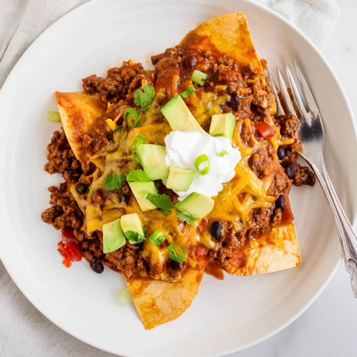 Beef Skillet Enchiladas bubbling with melted cheese, cilantro, and zesty sauce.