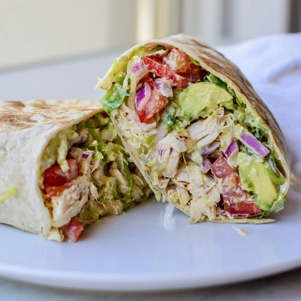 Skillet-toasted Chicken Avocado Ranch Burritos served halved, crisp tortilla and fresh cilantro