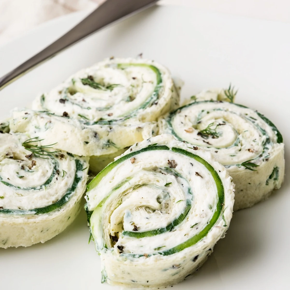 Party ready Cucumber And Dill Pinwheels garnished with extra dill, lemon zest.