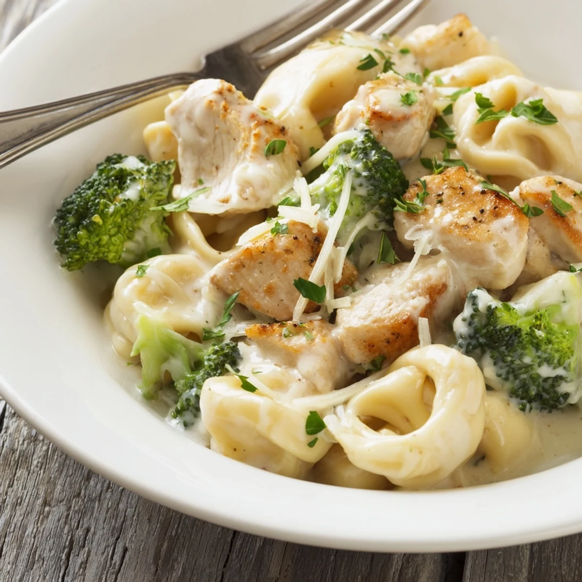 Saucy skillet of browned chicken and broccoli — Creamy Garlic Parmesan Tortellini Chicken Broccoli Recipe