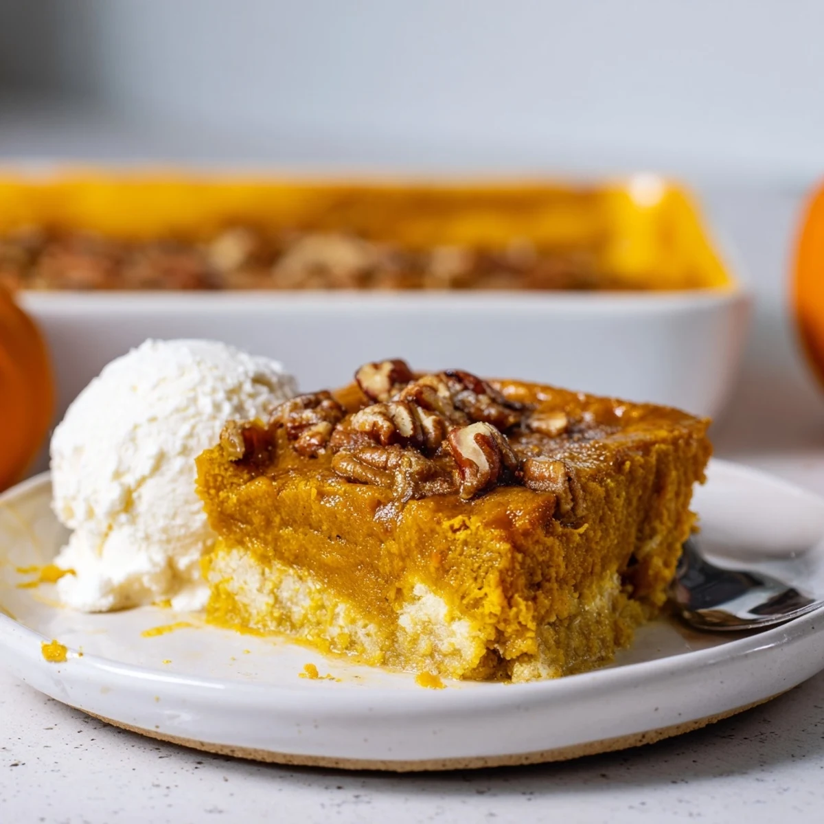 Spoon-ready Pumpkin Dump Cake served with melting vanilla ice cream