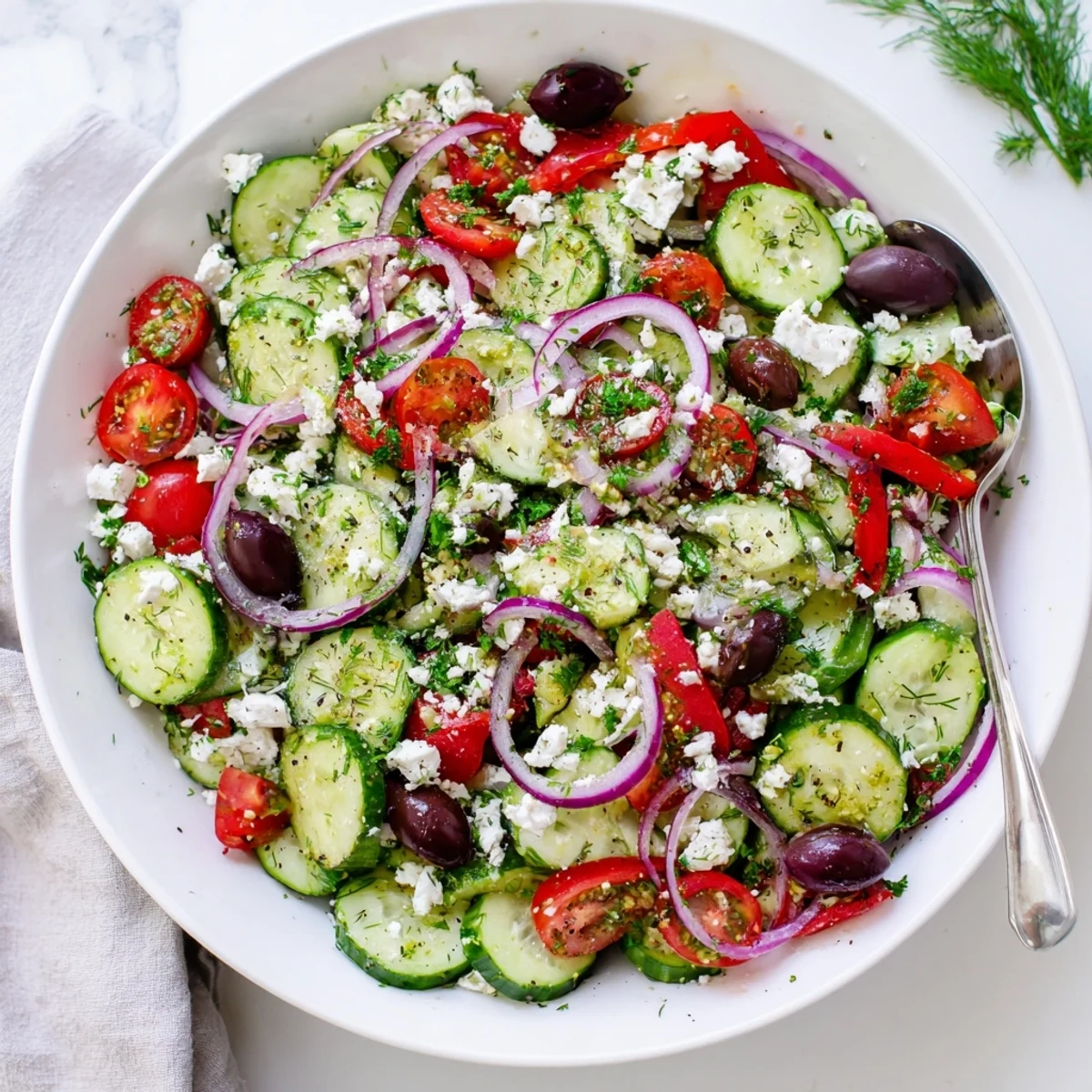 Colorful Mediterranean cucumber salad recipe featuring juicy tomatoes, red onion, and tangy feta cheese topping