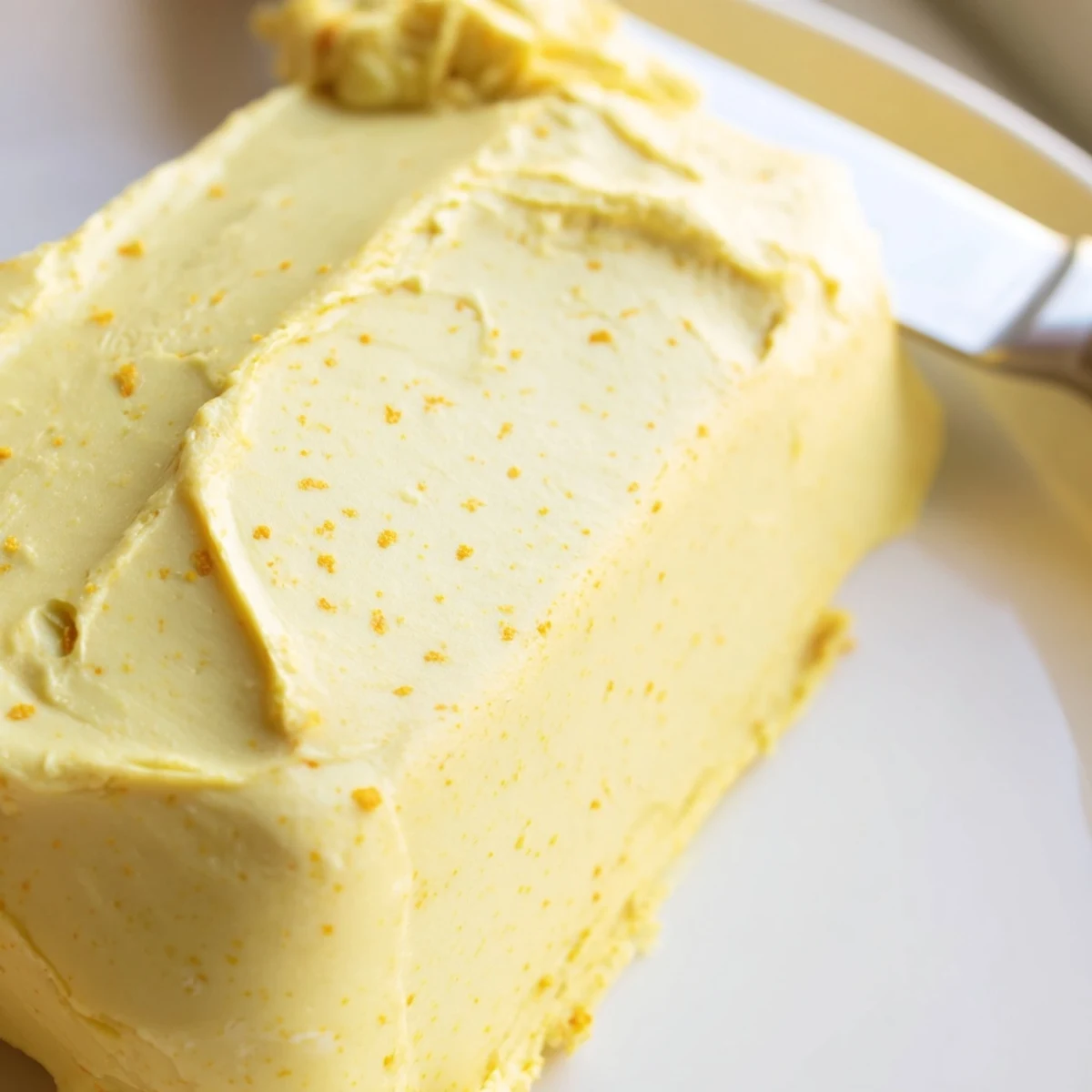 Smooth yellow vegan dairy free butter melting over warm stack of fluffy pancakes