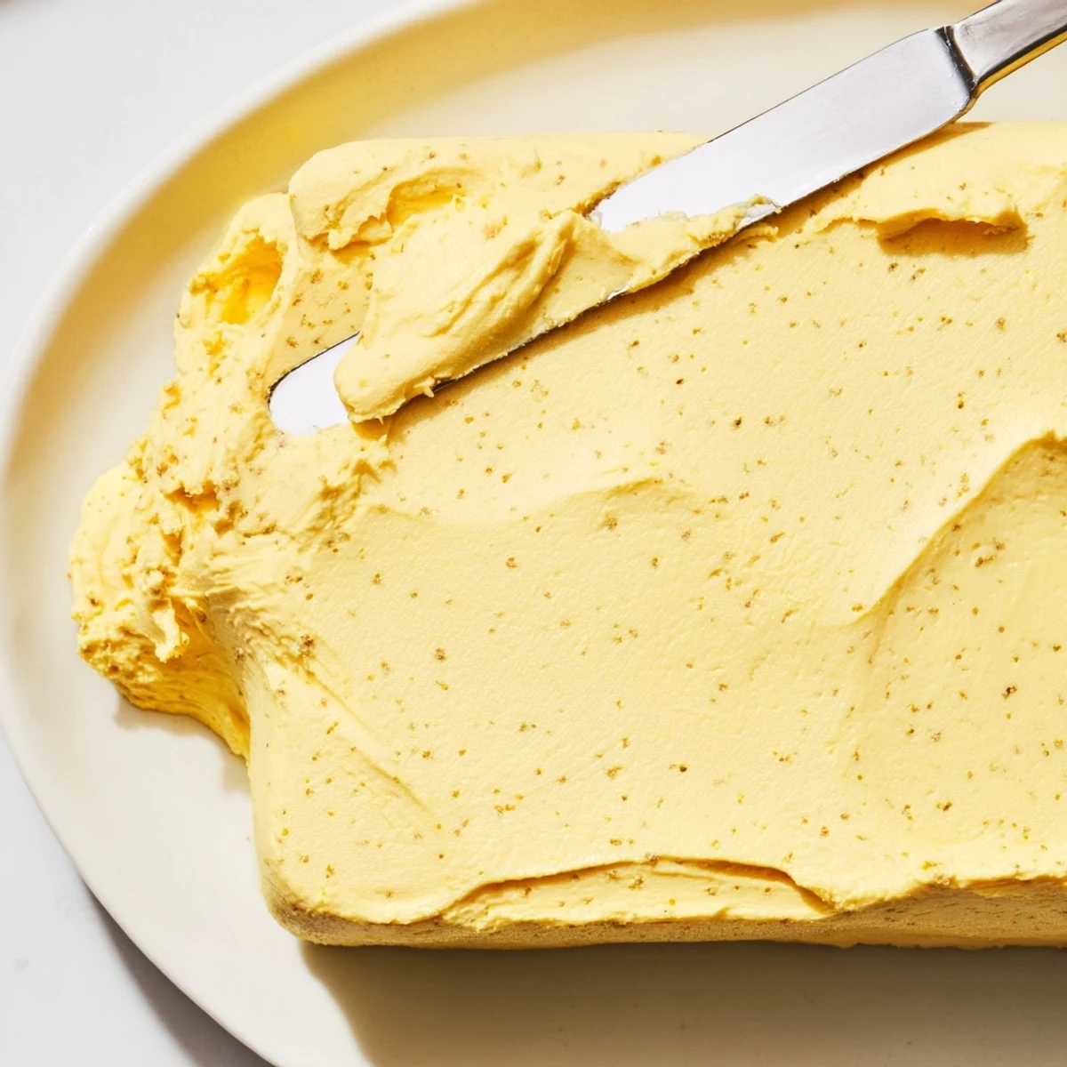 Creamy homemade vegan dairy free butter in glass container with visible coconut oil swirls