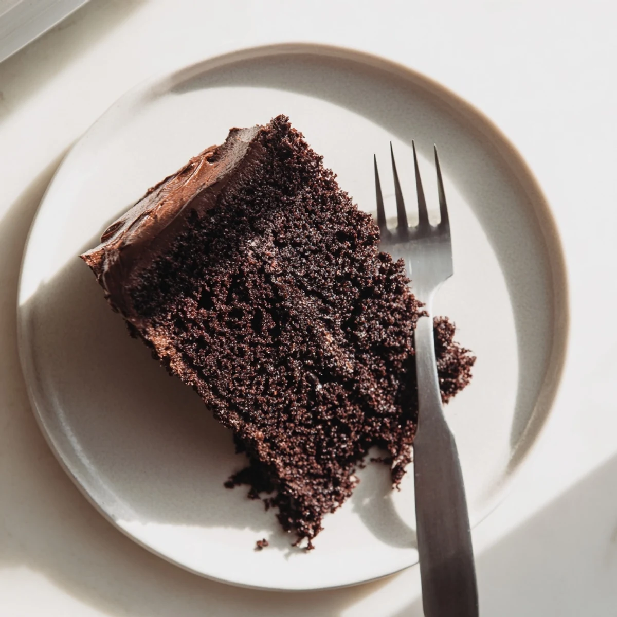 Homemade chocolate cake made with mayonnaise displaying moist cross-section and chocolate crumbs