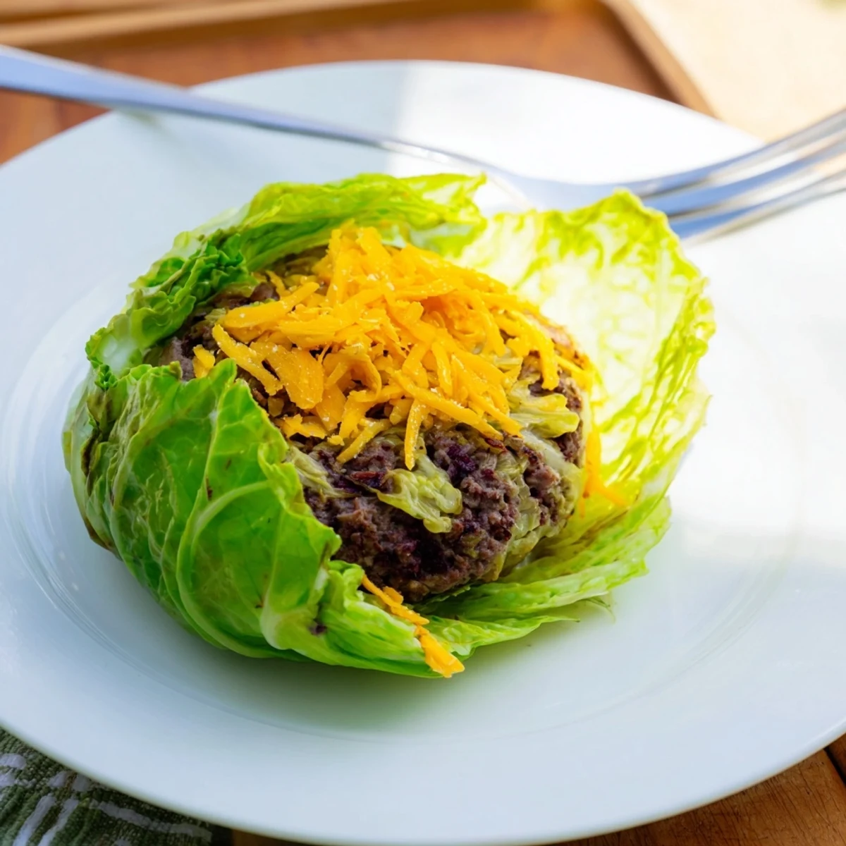 Golden oven baked cabbage burgers wrapped in tender green cabbage leaves on a baking sheet