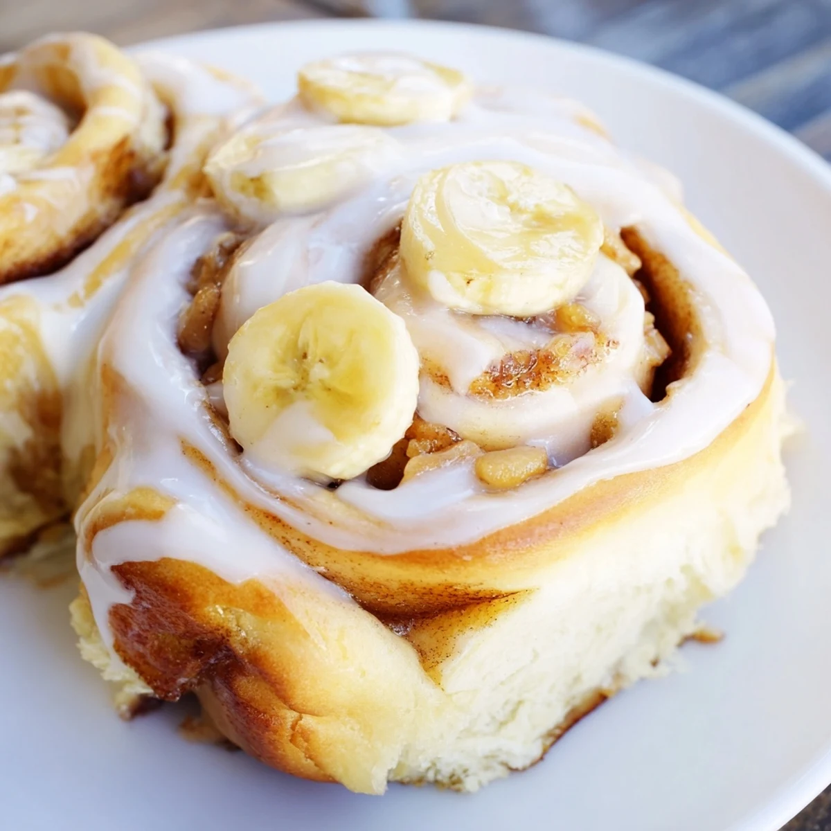 Homemade banana cinnamon rolls swirled with cinnamon slices and covered in white glaze