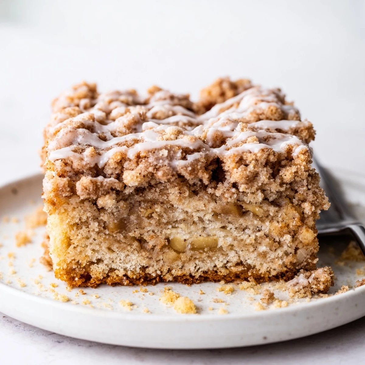 Moist Banana Crumb Coffee Cake drizzled with sweet vanilla glaze, served warm