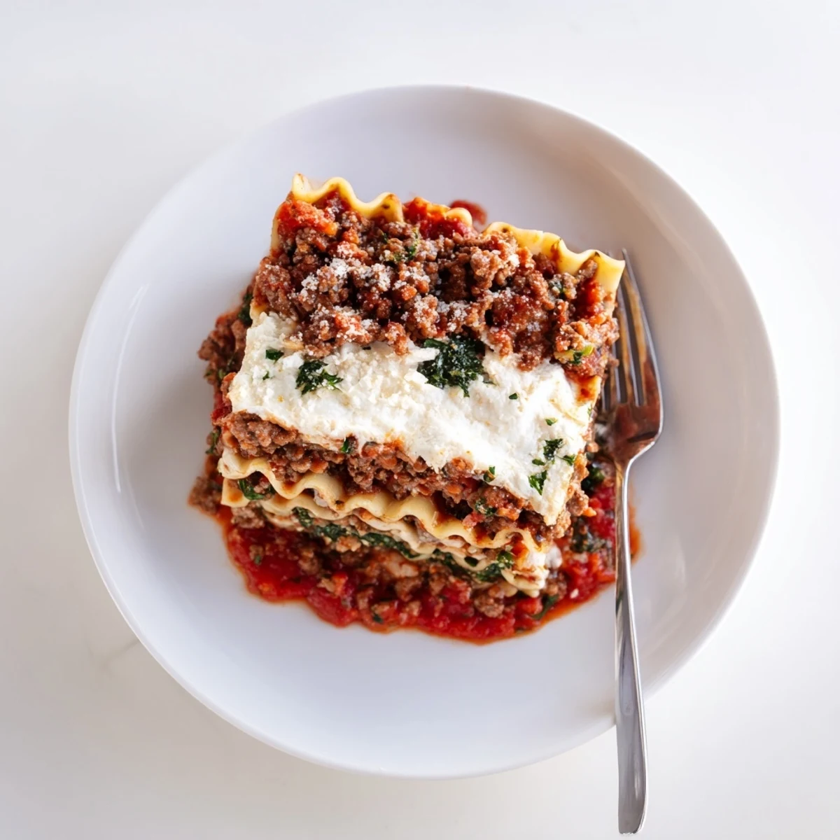 Hearty Slow Cooker Lasagna sliced on plate, fragrant basil, gooey cheese pull