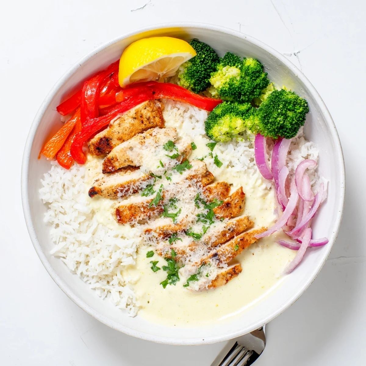 Grilled Chicken Broccoli Bowls with Creamy Garlic Sauce drizzled over warm fluffy rice