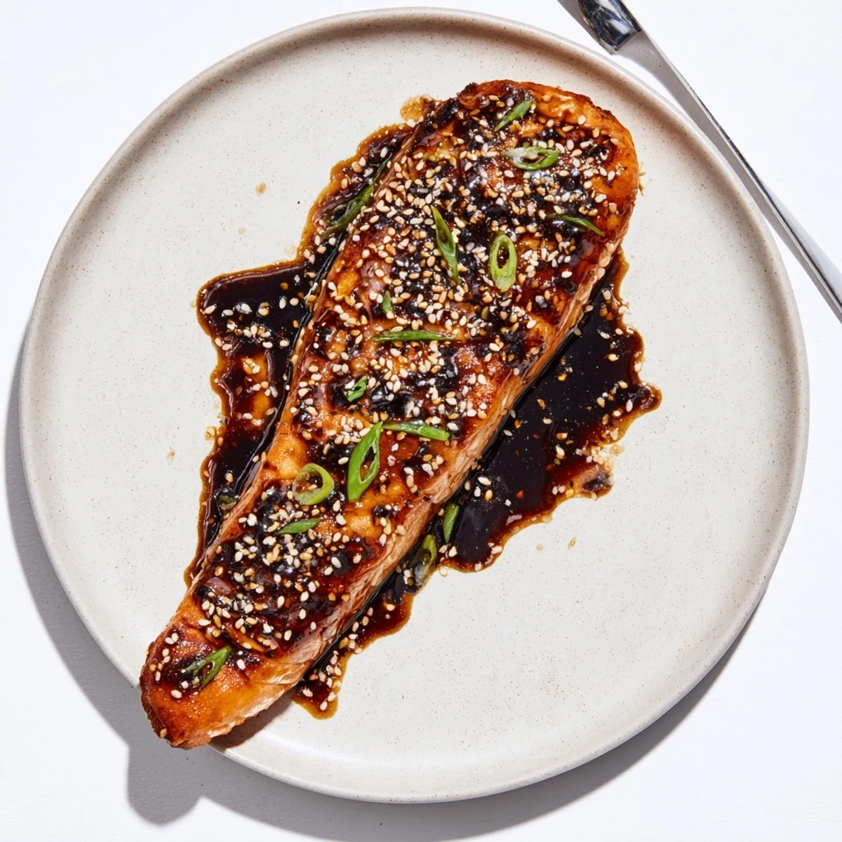 Baked Teriyaki Salmon glazed with sticky caramelized coating, sesame and scallions  