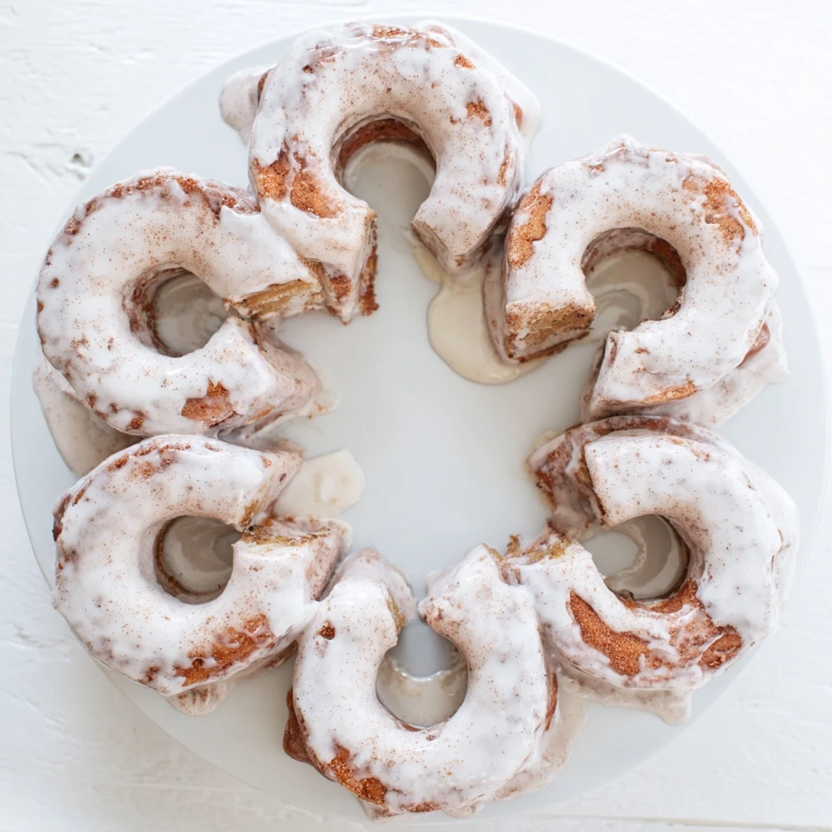 Baked banana bread donuts dusted with powdered sugar on a serving plate