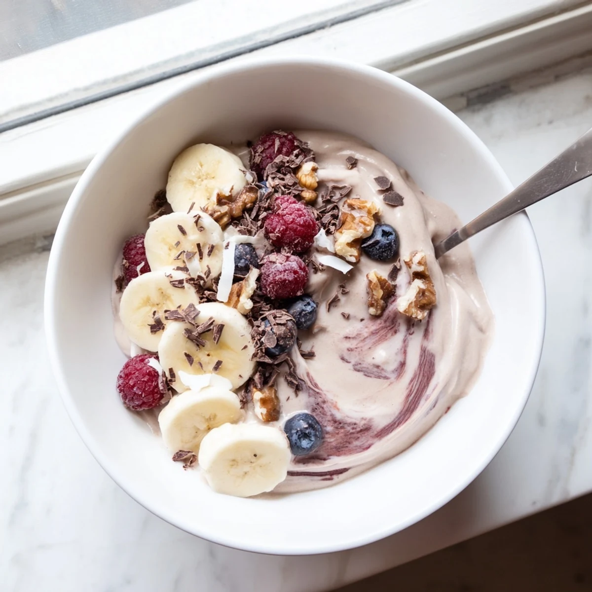 Creamy healthy nice cream recipe served in bowls with fresh banana slices and berries