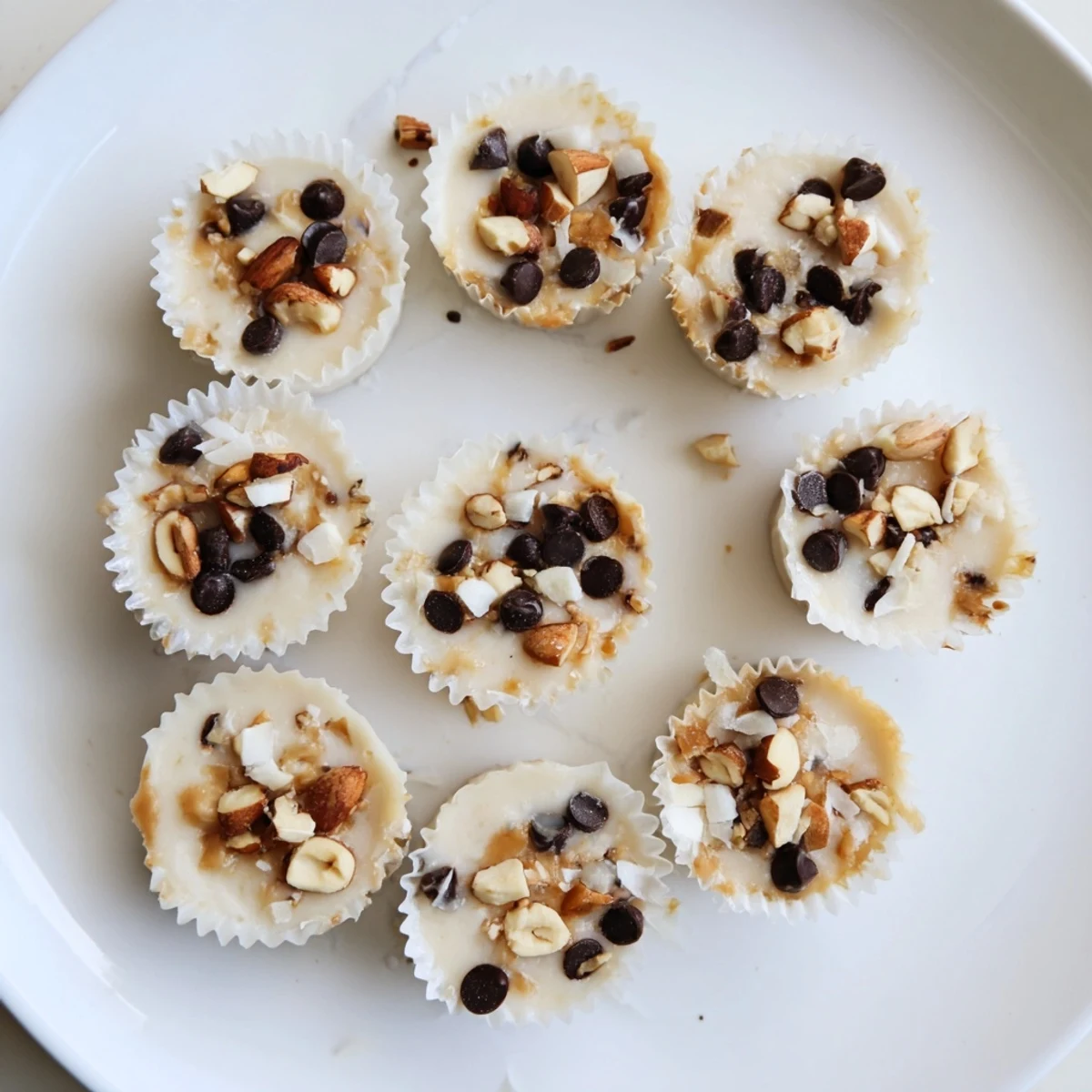 Golden frozen peanut butter Greek yogurt bites topped with melting chocolate chips and crushed peanuts