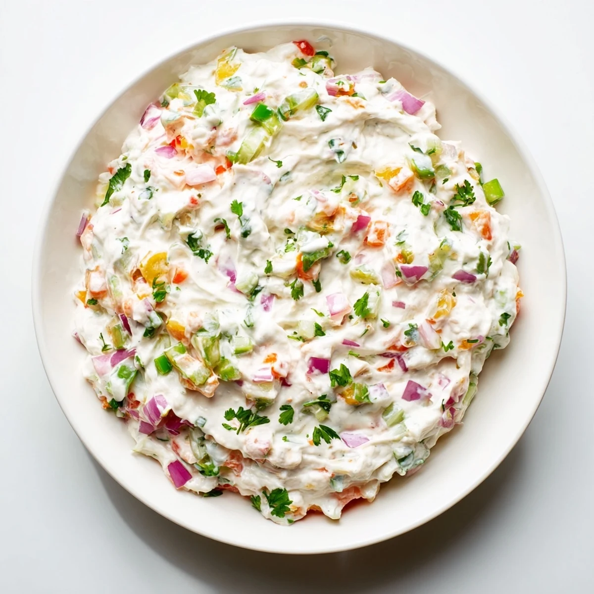 Creamy Grillos Pickle De Gallo Ranch Dip served in a white bowl with tortilla chips and fresh vegetable sticks on the side