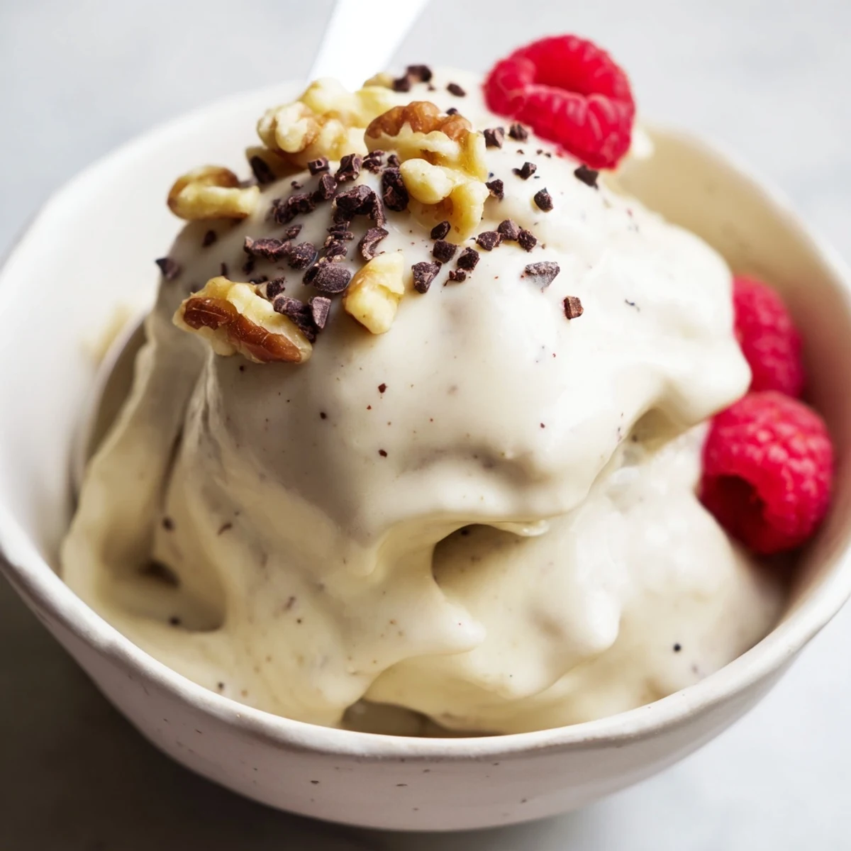 Dairy-free banana nice cream recipe swirling vanilla flavor with dark chocolate chip garnishes