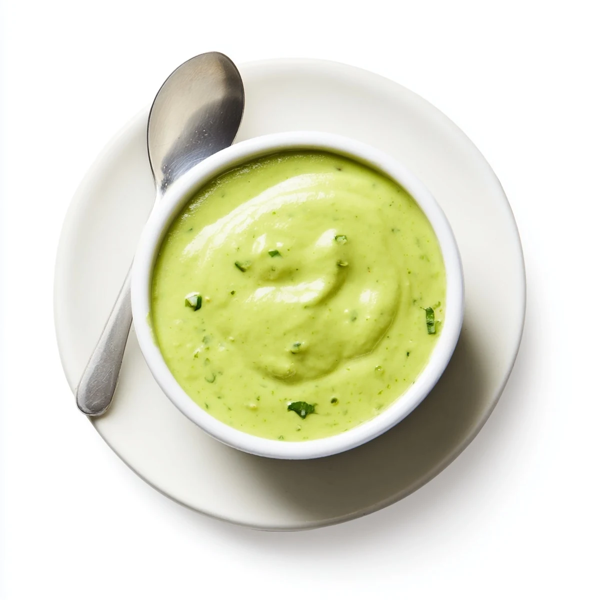 Creamy Peruvian green sauce aji verde drizzled over grilled chicken in a rustic bowl