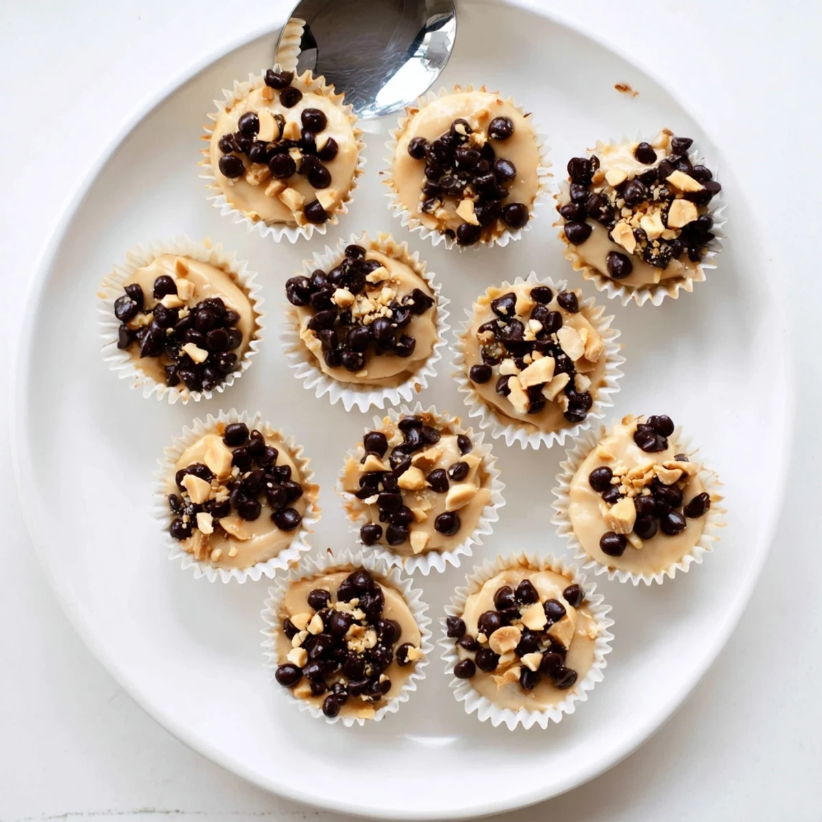 Golden frozen peanut butter Greek yogurt bites topped with melted dark chocolate and crushed peanuts