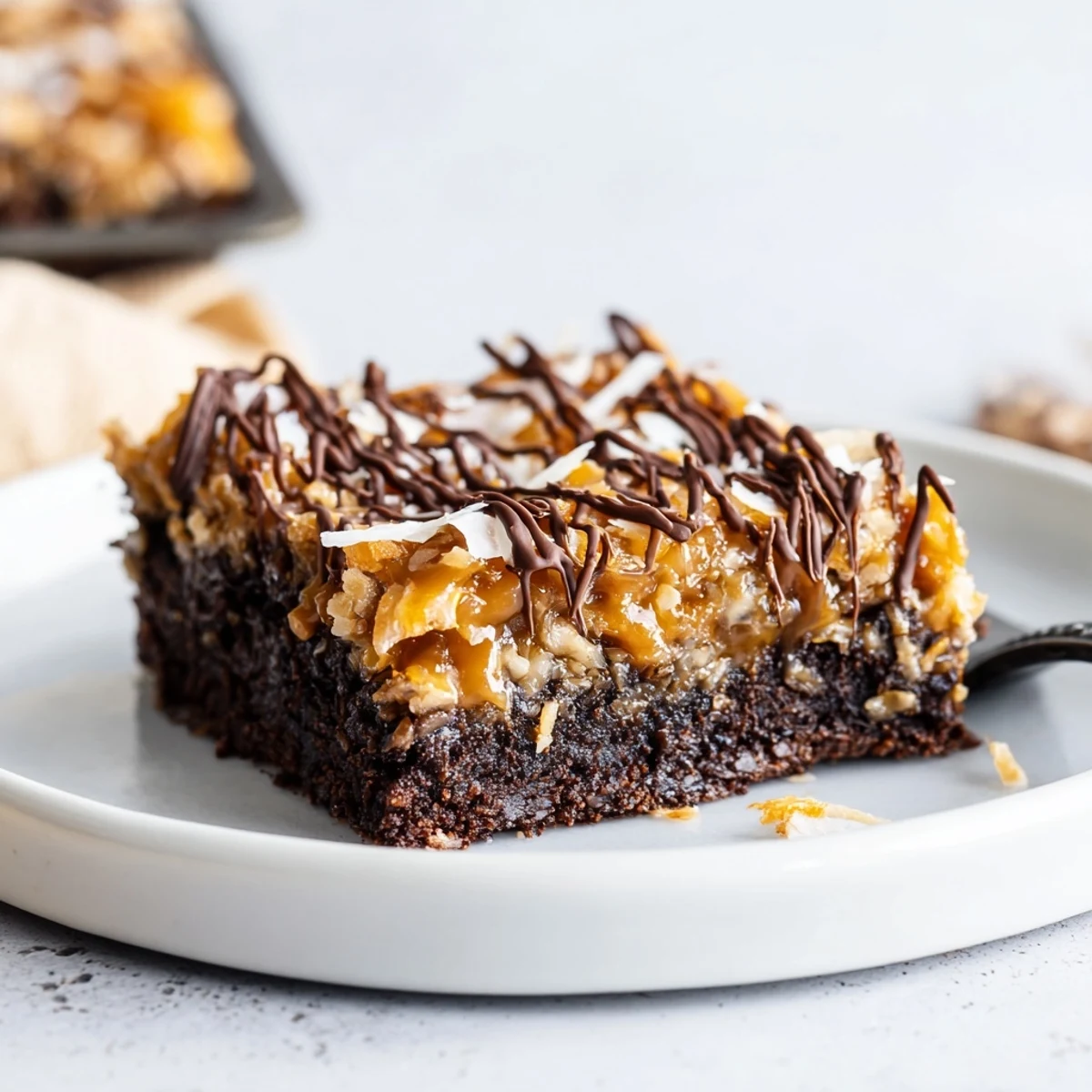 Freshly cut Samoa Brownies on parchment, gooey caramel and crunchy coconut
