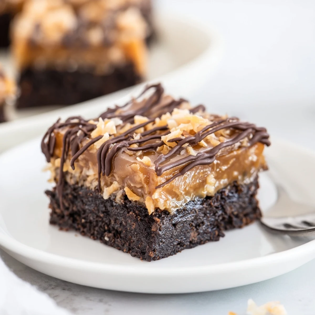 Bite-ready Samoa Brownies topped with caramel-coconut layer, chilled for clean slicing