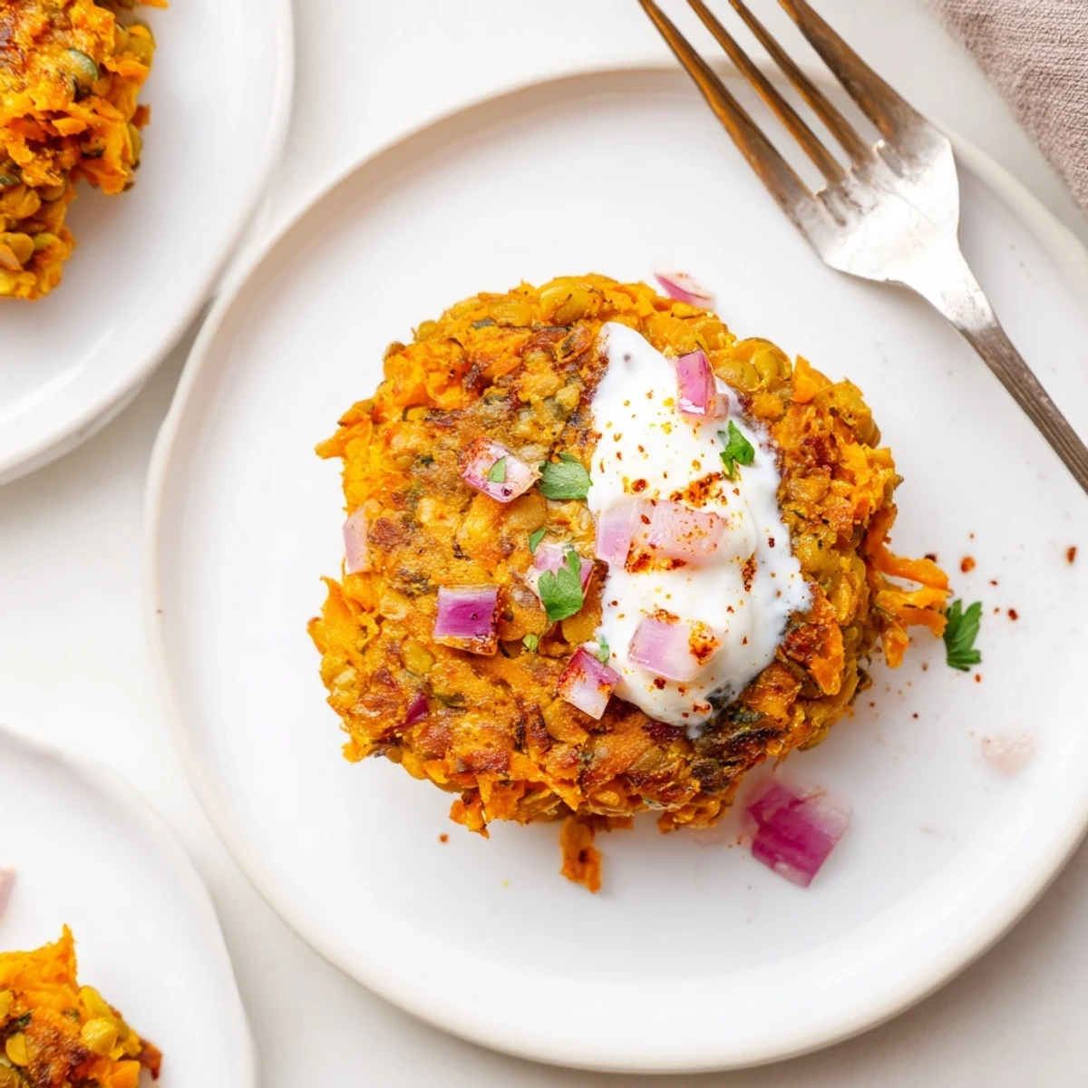 Crispy Sweet Potato Lentil Patties stacked, golden edges, served with yogurt dip.  