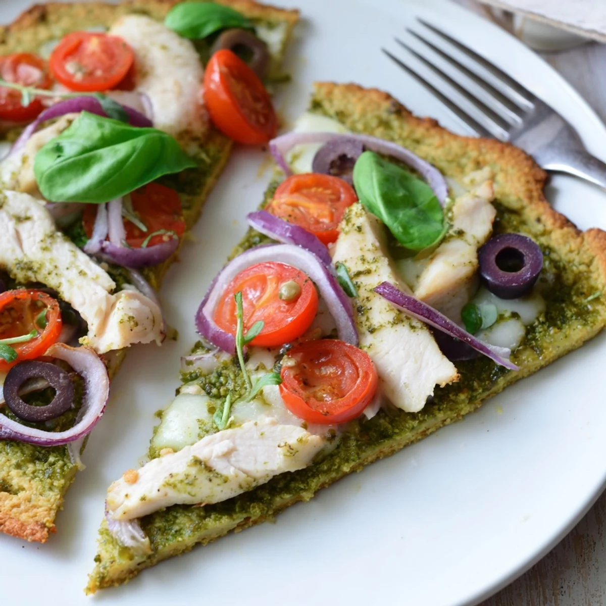 Plate of Chicken Pesto Paleo Pizza hot from oven paired with crisp green salad