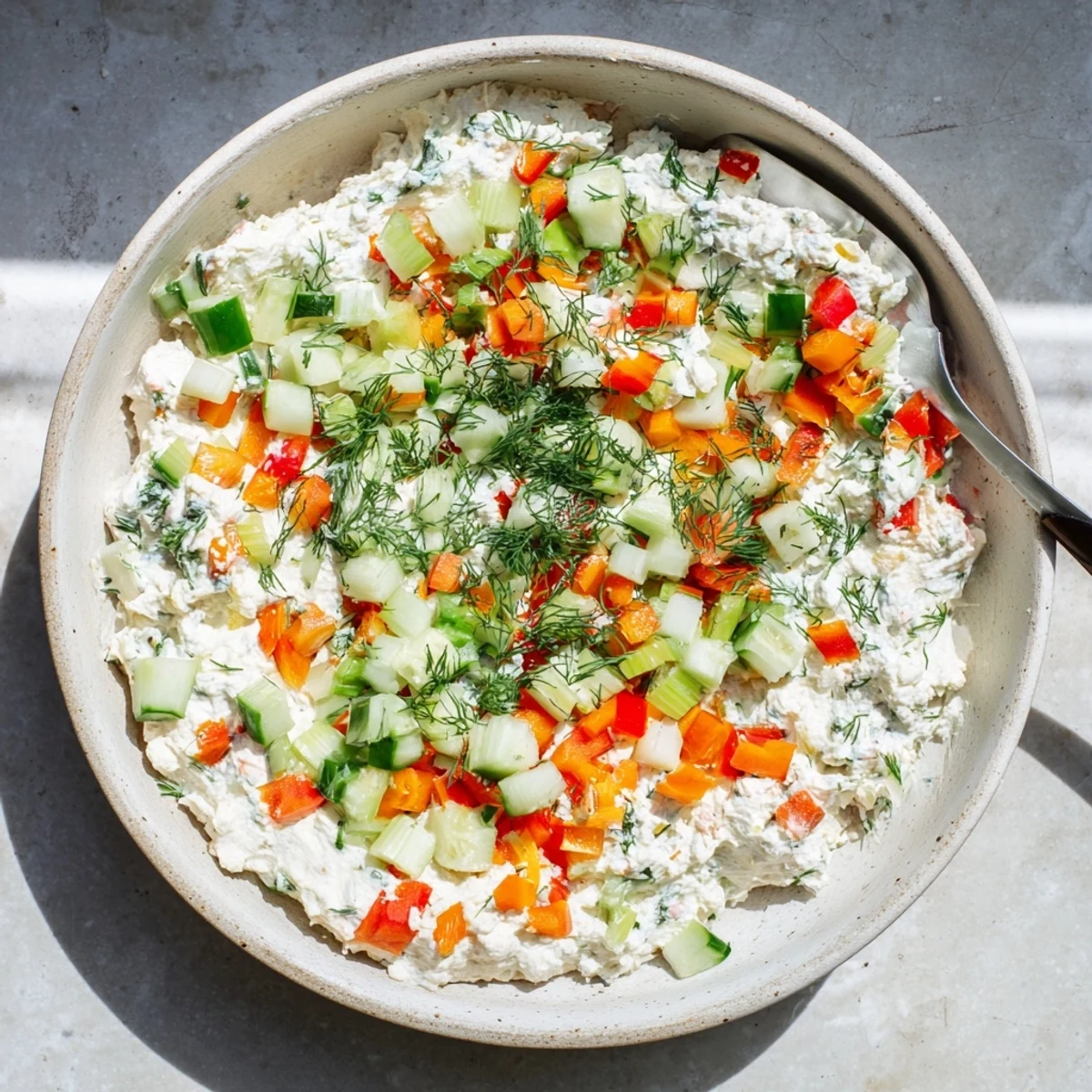 Garden vegetable spread featuring fresh peppers, cucumber, and herbs blended into smooth cream cheese