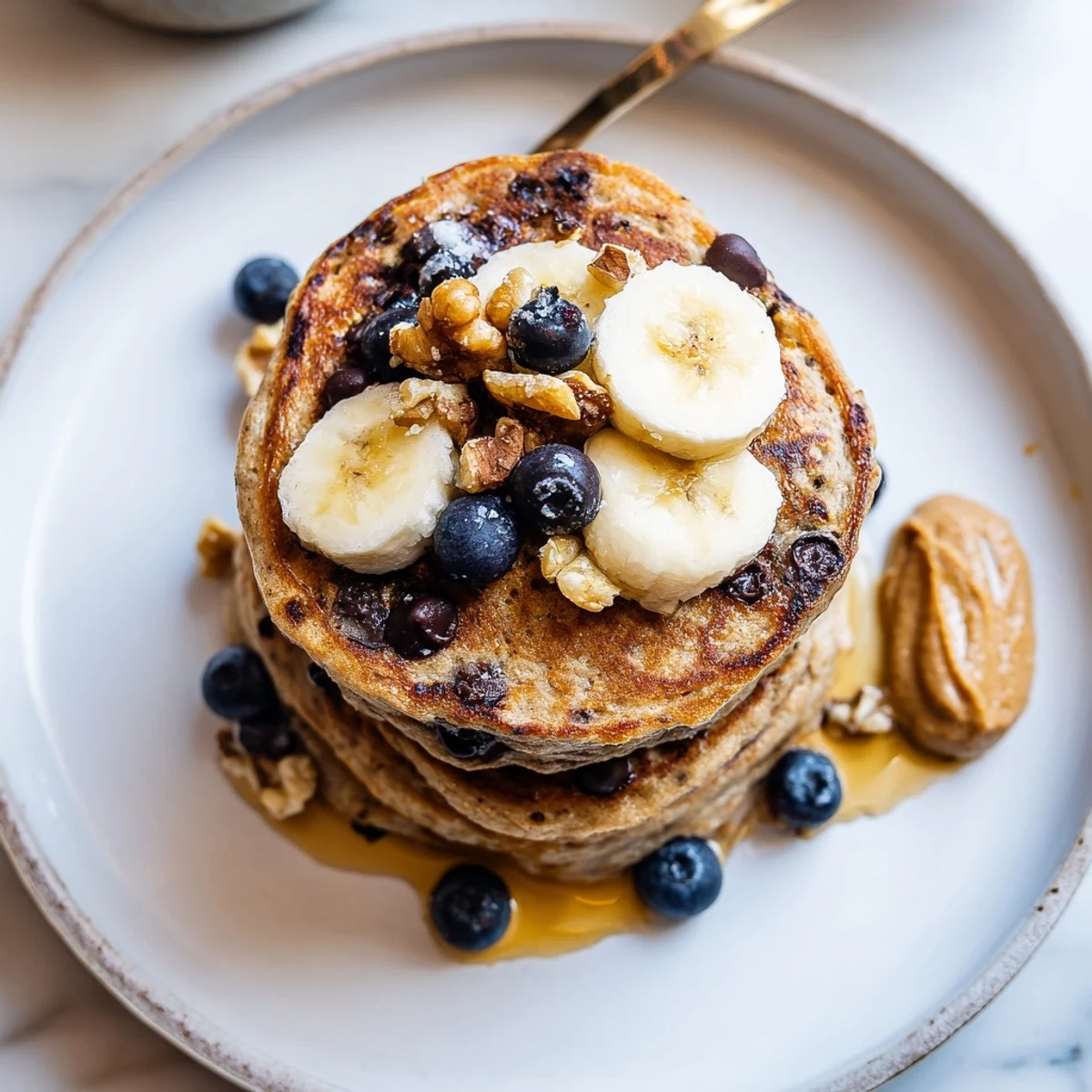 Warm Protein Banana Pancakes on griddle, fluffy texture, maple syrup drizzle