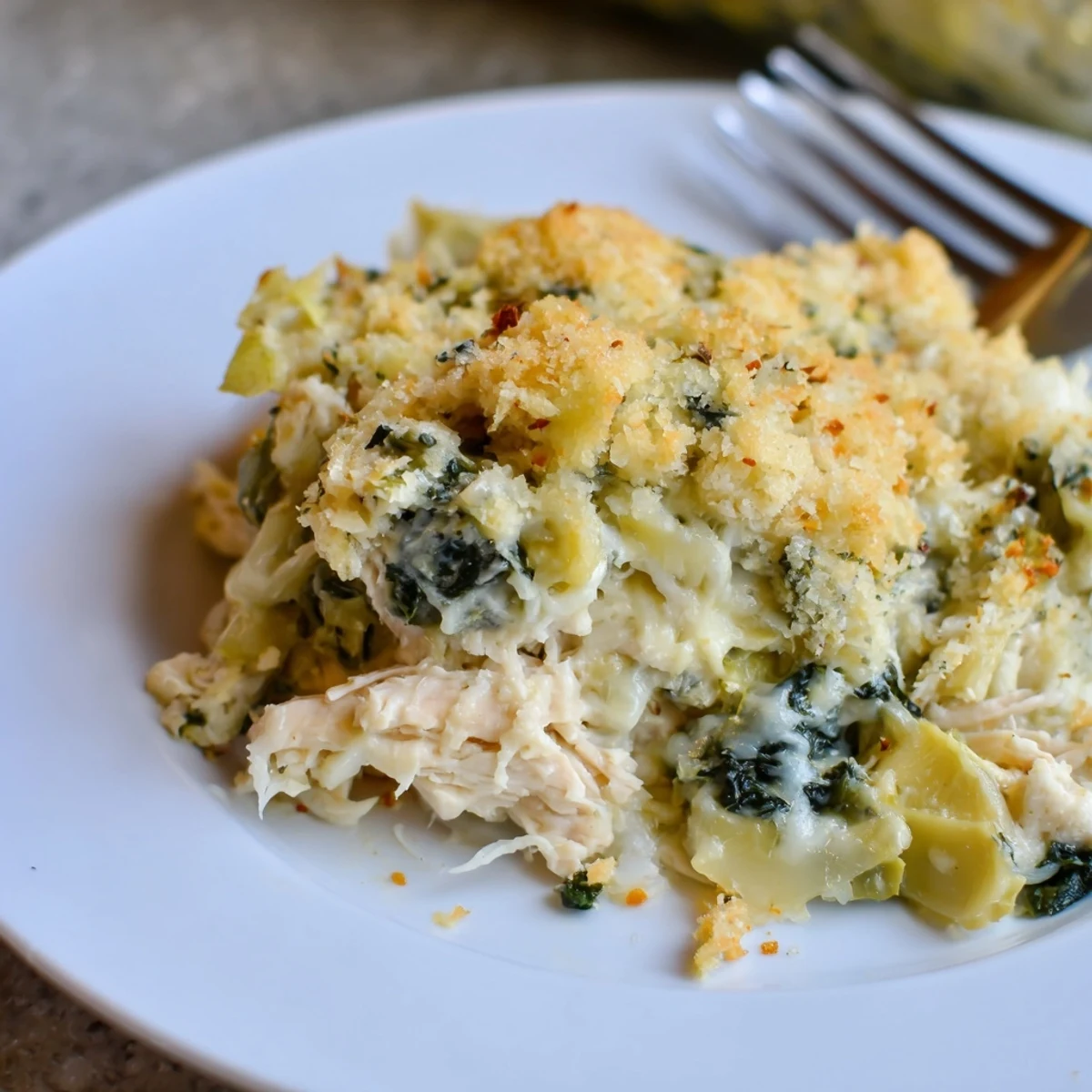 Spinach Artichoke Chicken Casserole bubbling with browned top and creamy filling