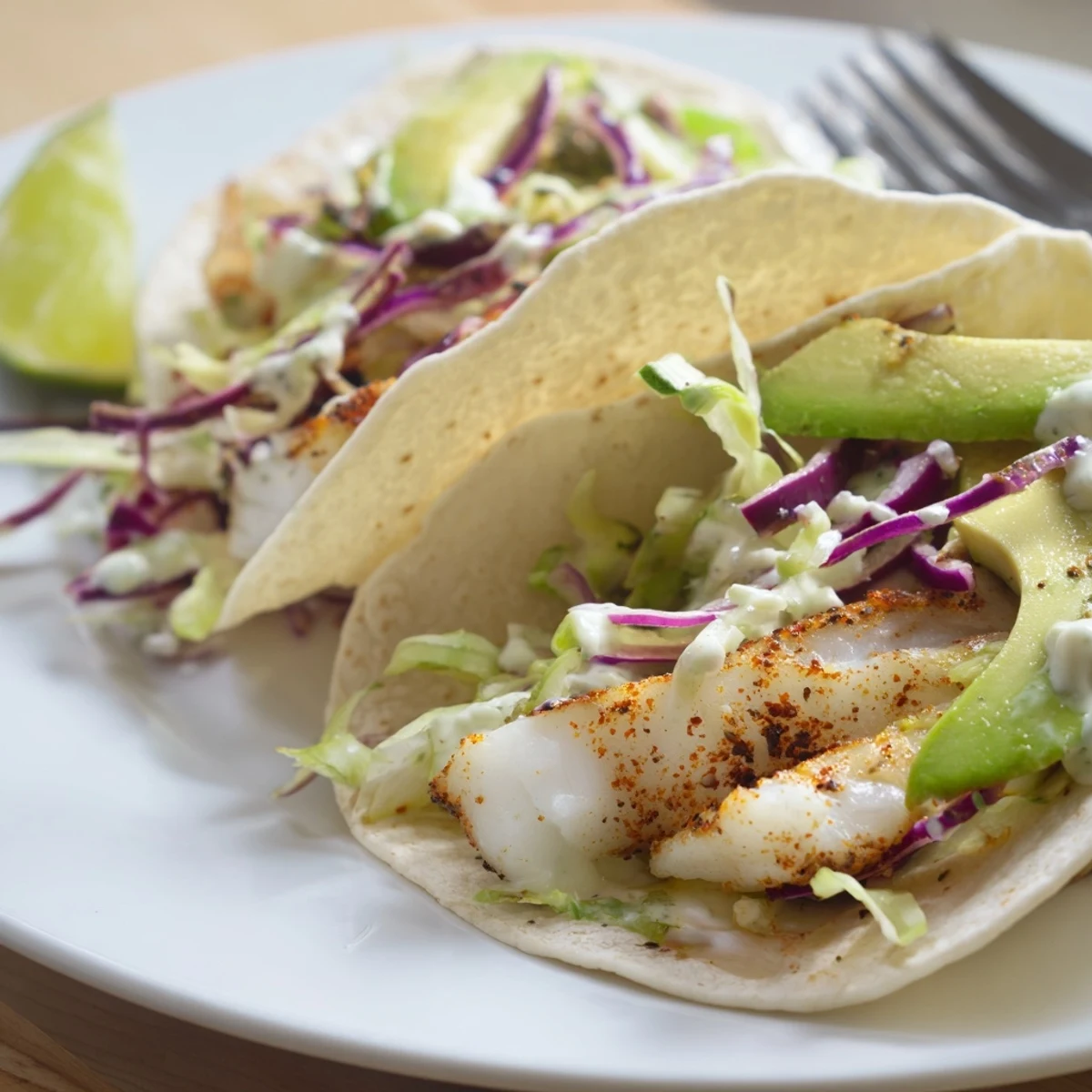 Sizzling sheet-baked fillets make Baked Cod Fish Tacos with Creamy Cilantro Lime Sauce