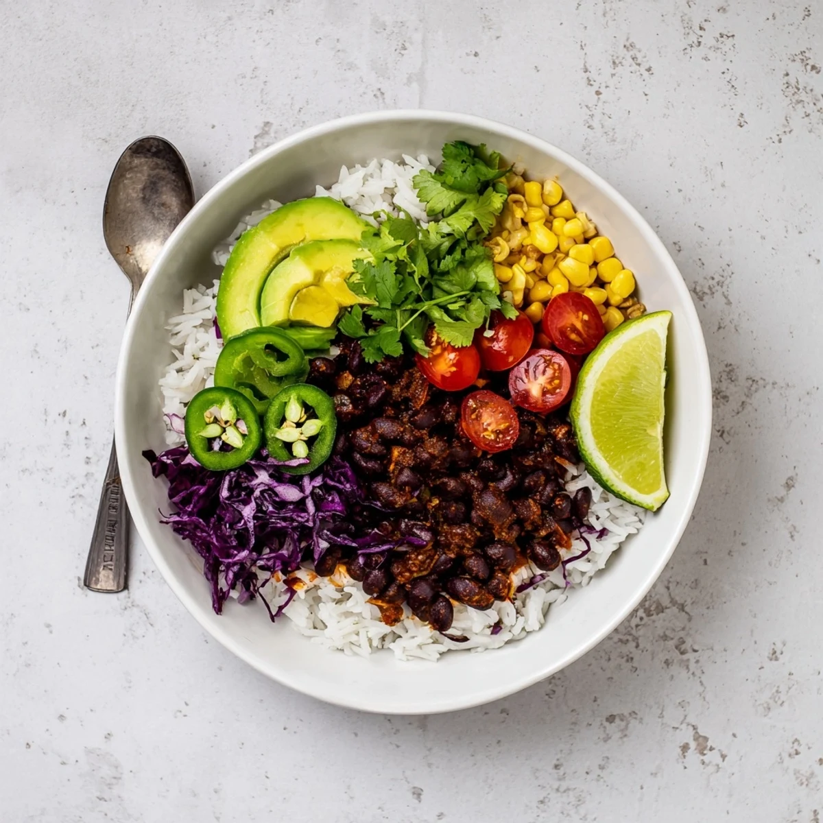 Steaming black bean and rice bowl served in a rustic dish with vibrant toppings