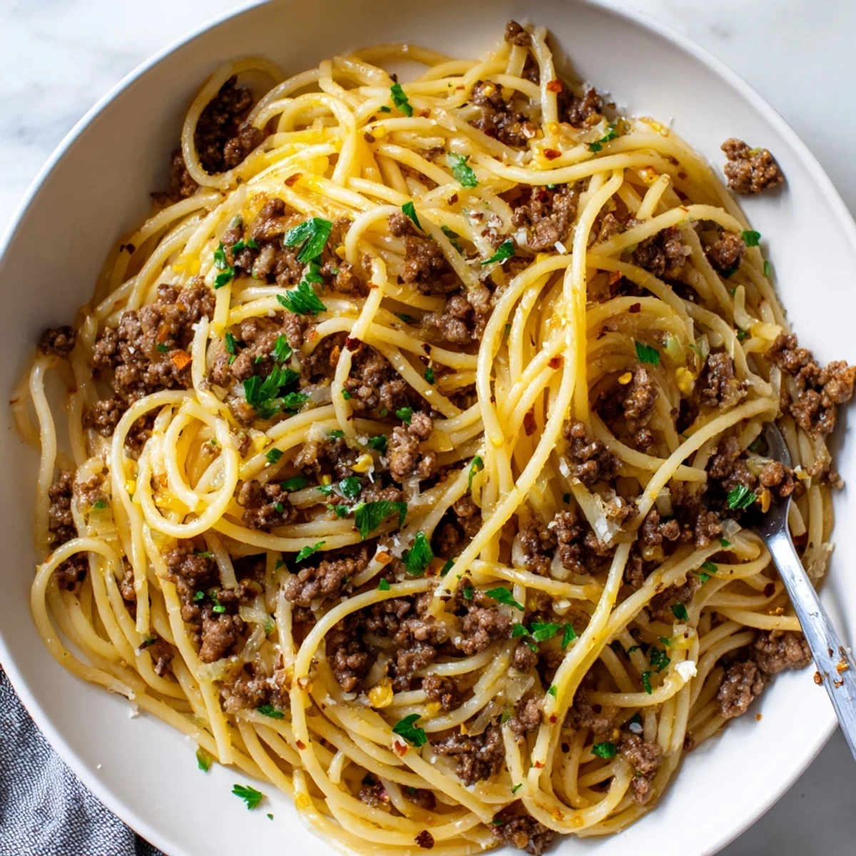 Garlic Butter Pasta with Ground Beef coated in a silky Parmesan sauce on a plate
